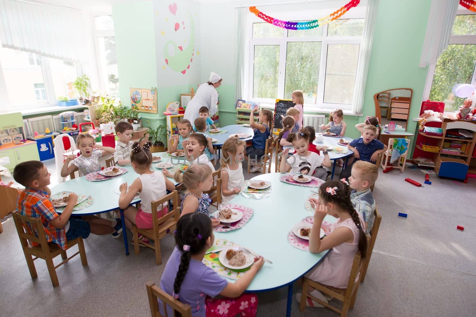 Belarus, Gomel, May 29, 2018. The kindergarten is central. Open Day.Many children in the kindergarten eat at the table.Lunch for children. by Sviatlana