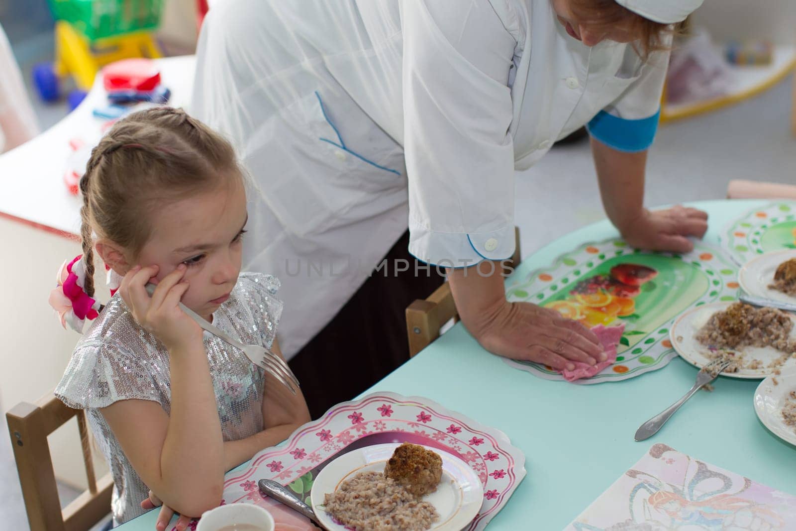 Belarus, Gomel, May 29, 2018. The kindergarten is central. Open Day.Lunch in the kindergarten. ?hild does not want to eat. Bad appetite. Eating in kindergarten by Sviatlana