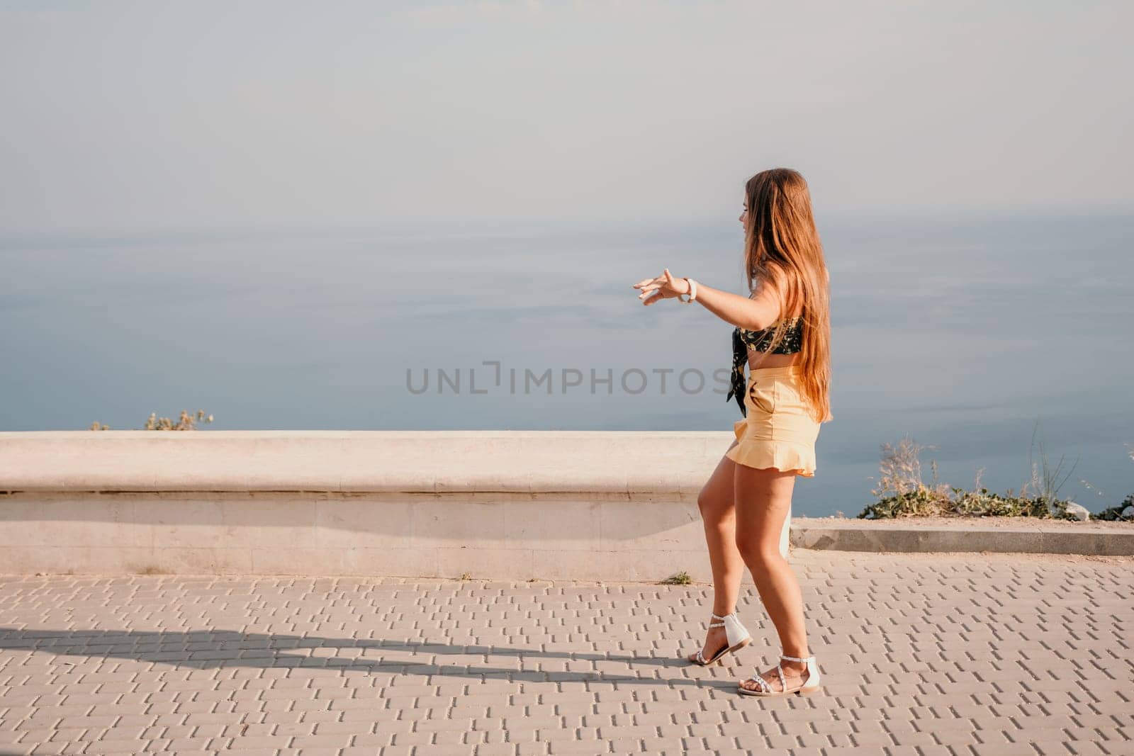 Woman summer dance. Silhouette of a happy woman who dances, spins and raises her hands to the sky. A playful young woman enjoys her happy moment dancing in the rays of the golden sun. by panophotograph