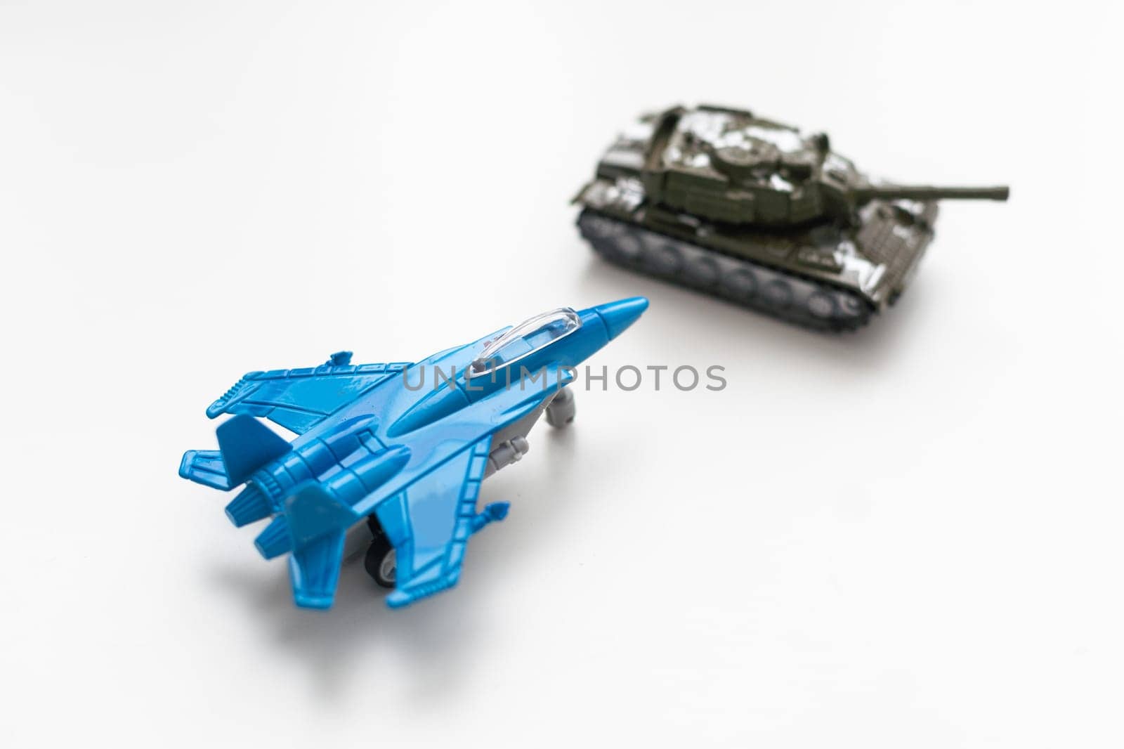 The image shows models of tanks and fighter jets on a white background, close up. High quality photo