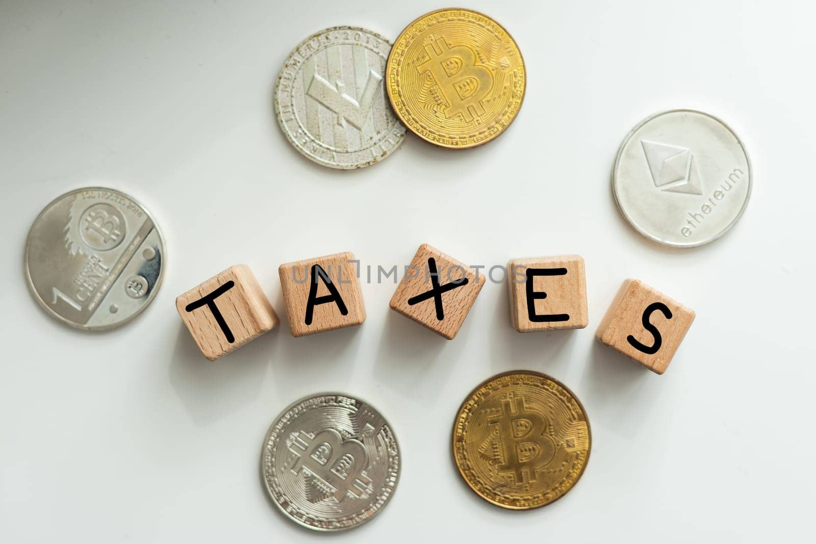 TAXES - word on wooden cubes on the background of coins and calculator. Business and finance concept. High quality photo