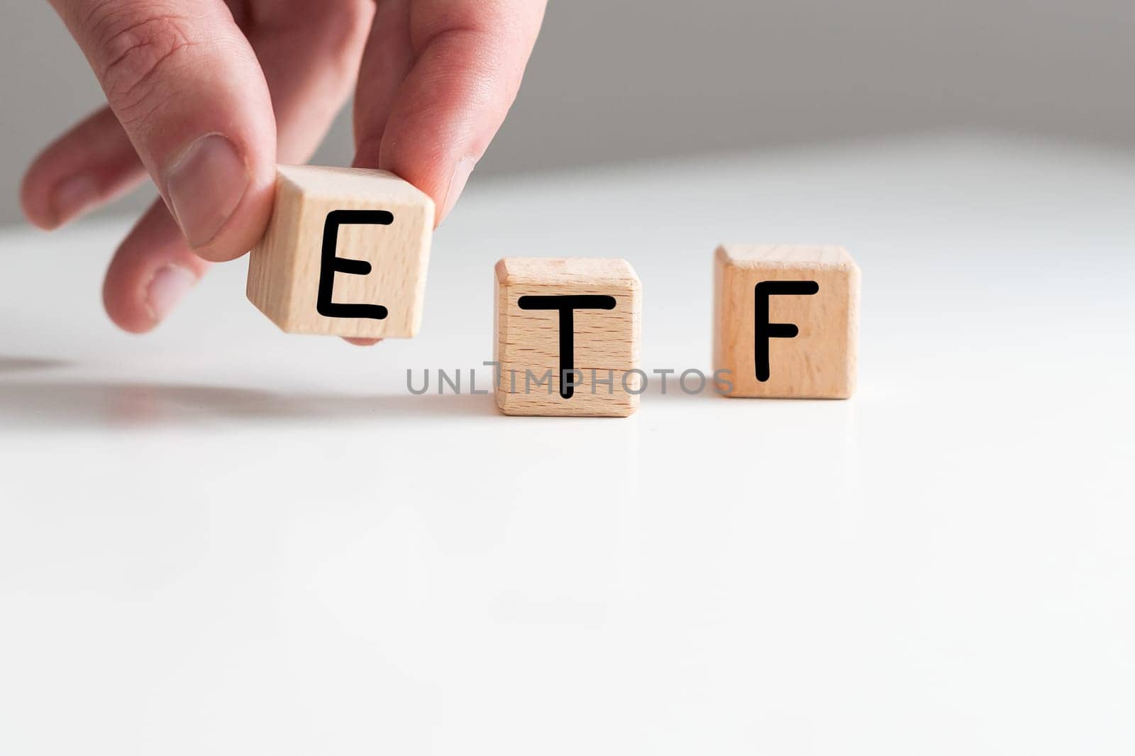 ETF word written on wood block on chart background . High quality photo