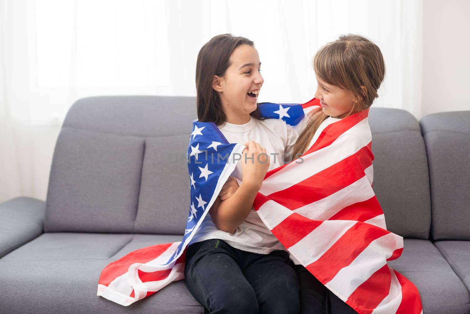 cheerful adorable kids standing under american flag and looking at. High quality photo