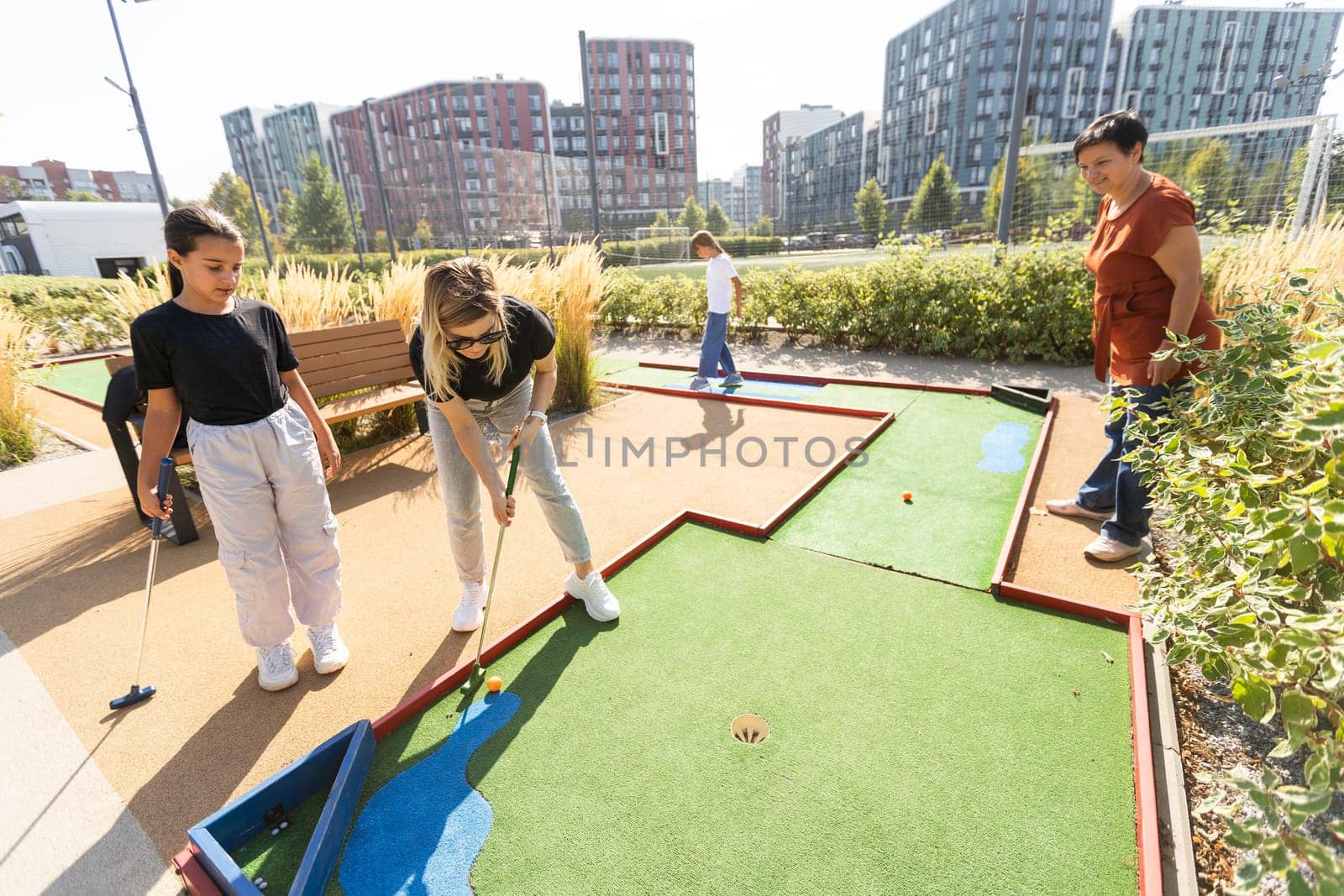 family playing mini golf on a cruise liner. Child having fun with active leisure on vacations. by Andelov13