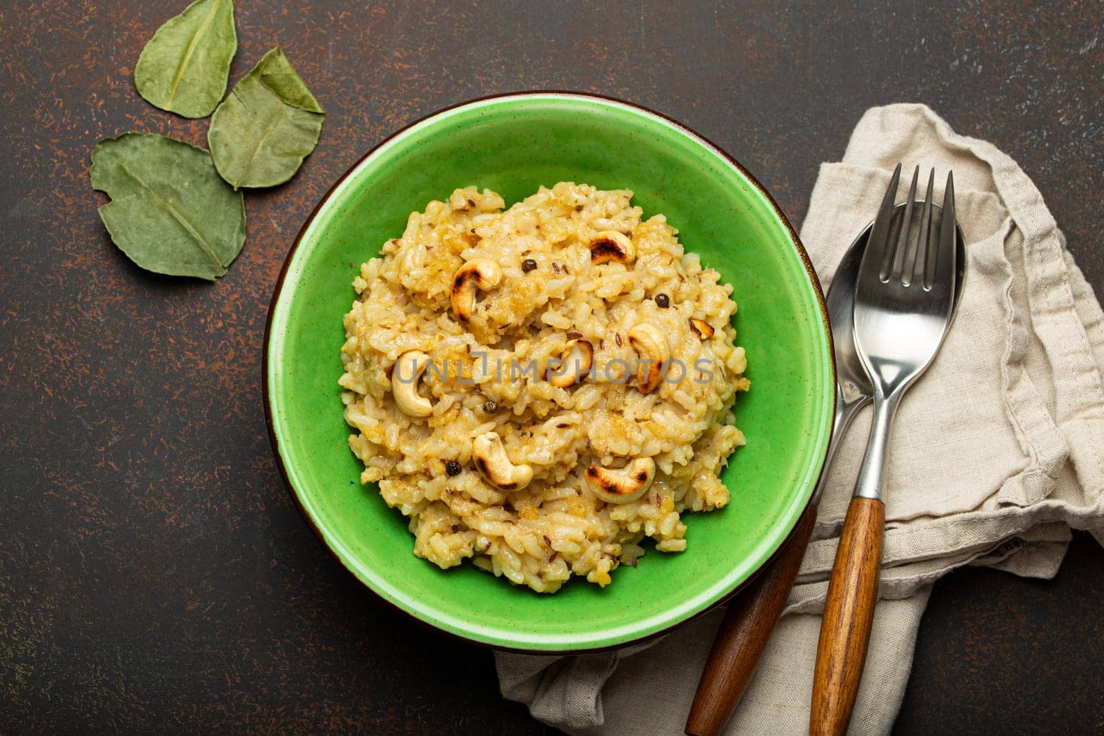 Ven Pongal (Khara Pongal), traditional Indian savoury rice dish made during celebrating Pongal festival, served in bowl top view on concrete rustic background.