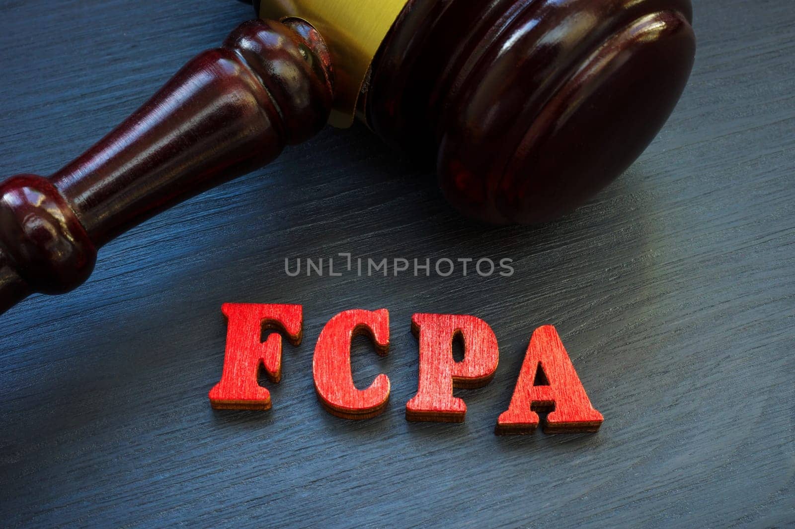 Gavel and letters FCPA Foreign Corrupt Practices Act on a wooden surface. by designer491