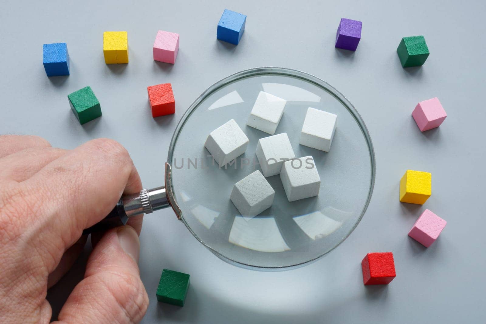 Ethnocentrism concept. White cubes and magnifying glass. by designer491