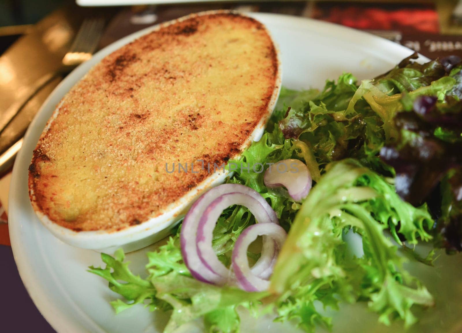 Gratin with fish and cheese with green salad and onions by Godi