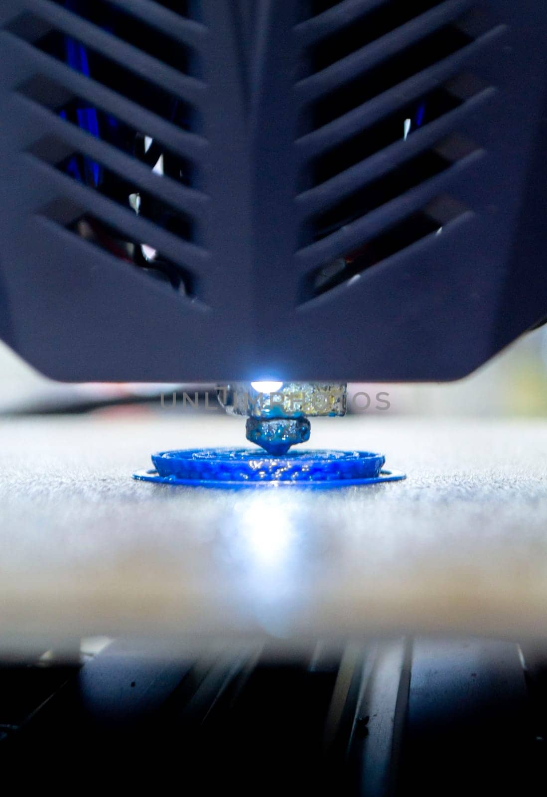 Working 3D printer printing object from blue plastic. Printing model from molten plastic using a 3D printer. Creation of a form by a 3D printer. Additive progressive new modern 3d printer technology