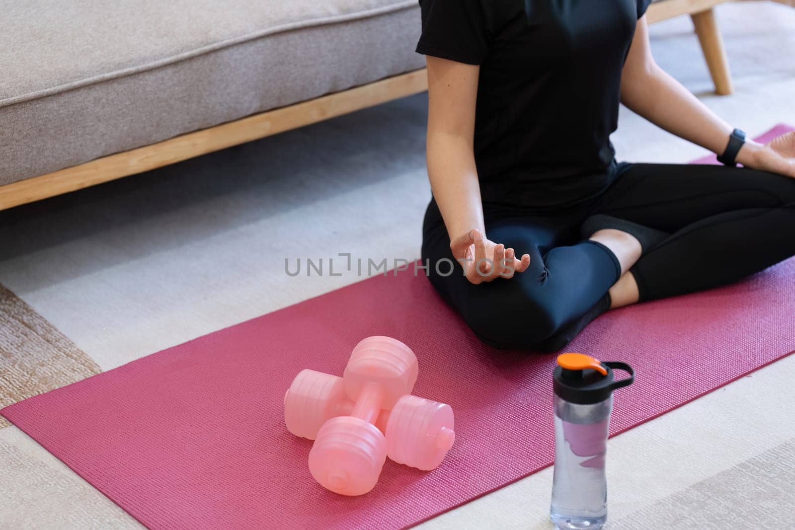 Young woman practicing lotus asana in yoga studio. Padmasana pose.