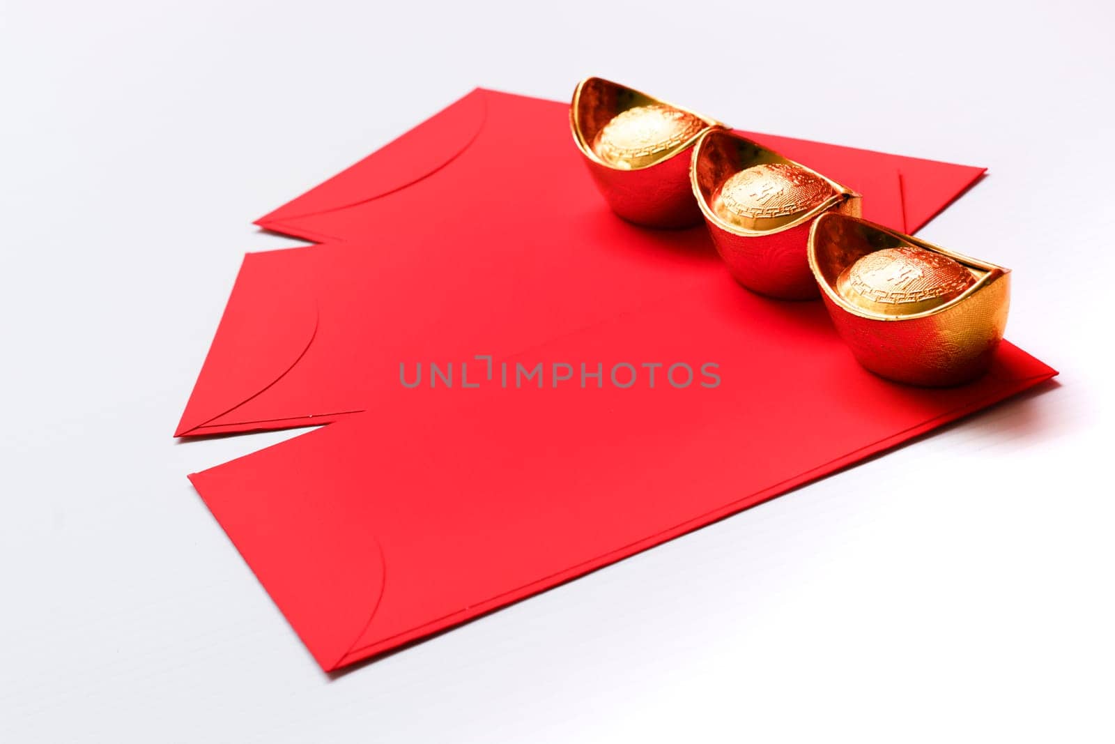 Chinese New Year Spring festival decorations red packet and gold ingots on white background.