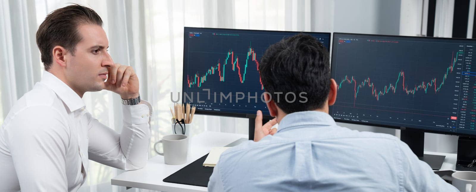 Stock exchange traders discussing on market stock comparing with two screen in chart on panorama view, analyzing on monitor. Concept of financial technology crisis situation at workplace. Sellable.