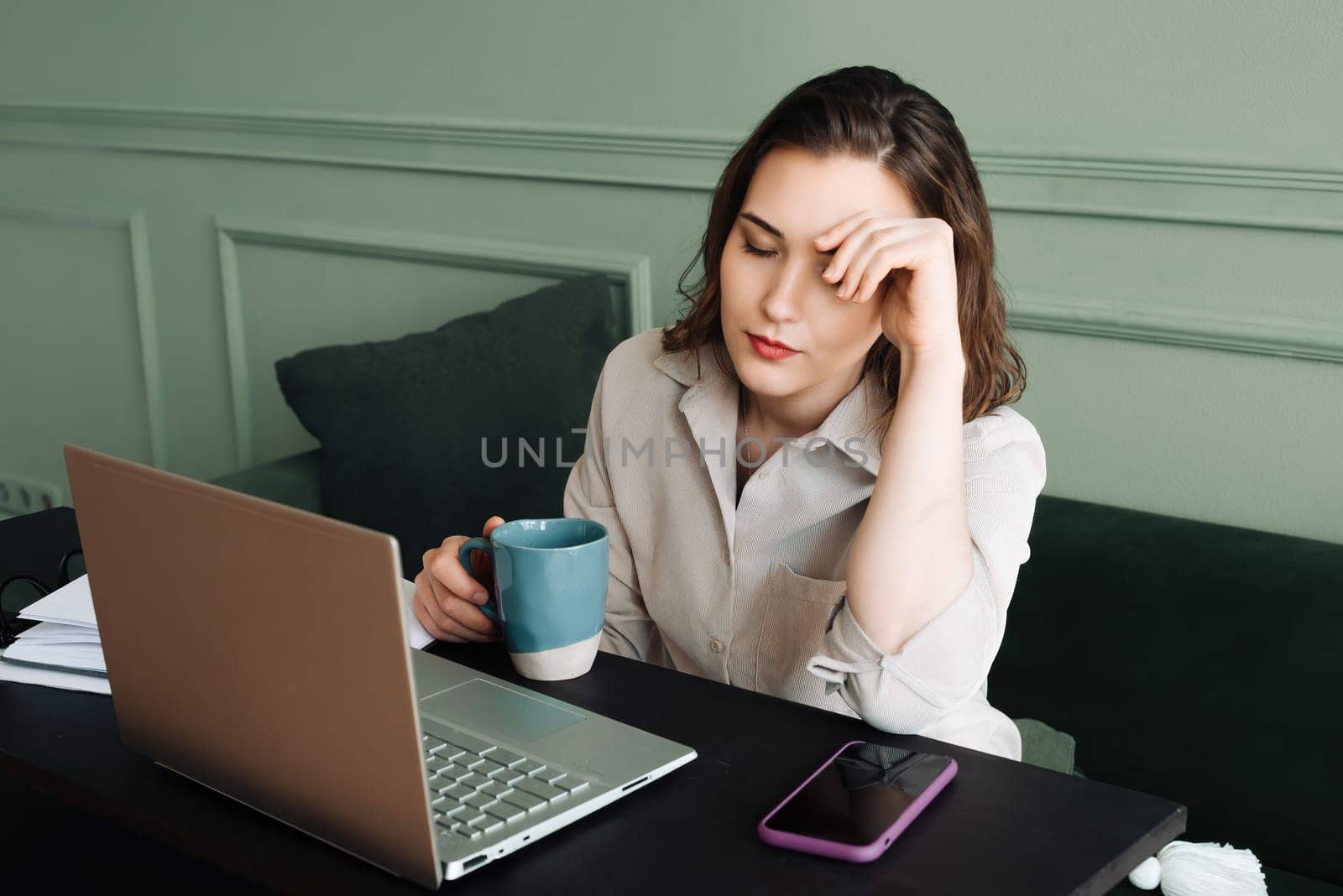 Work-Induced Stress. Tired Middle-Aged Woman with Laptop. Stress and Fatigue. Middle-Aged Woman Struggles with Laptop Work. Overworked and Drained. Middle-Aged Woman with Coffee and Laptop.