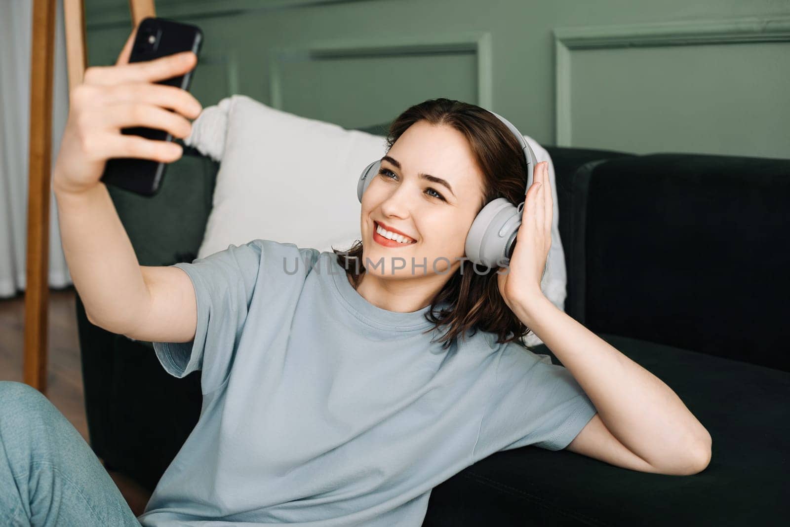 A cheerful young woman wearing wireless headphones listening to music. Musical Bliss. Joyful Young Woman Immersed in Melodies with Wireless Headphones. Smiling Woman Lost in Music.