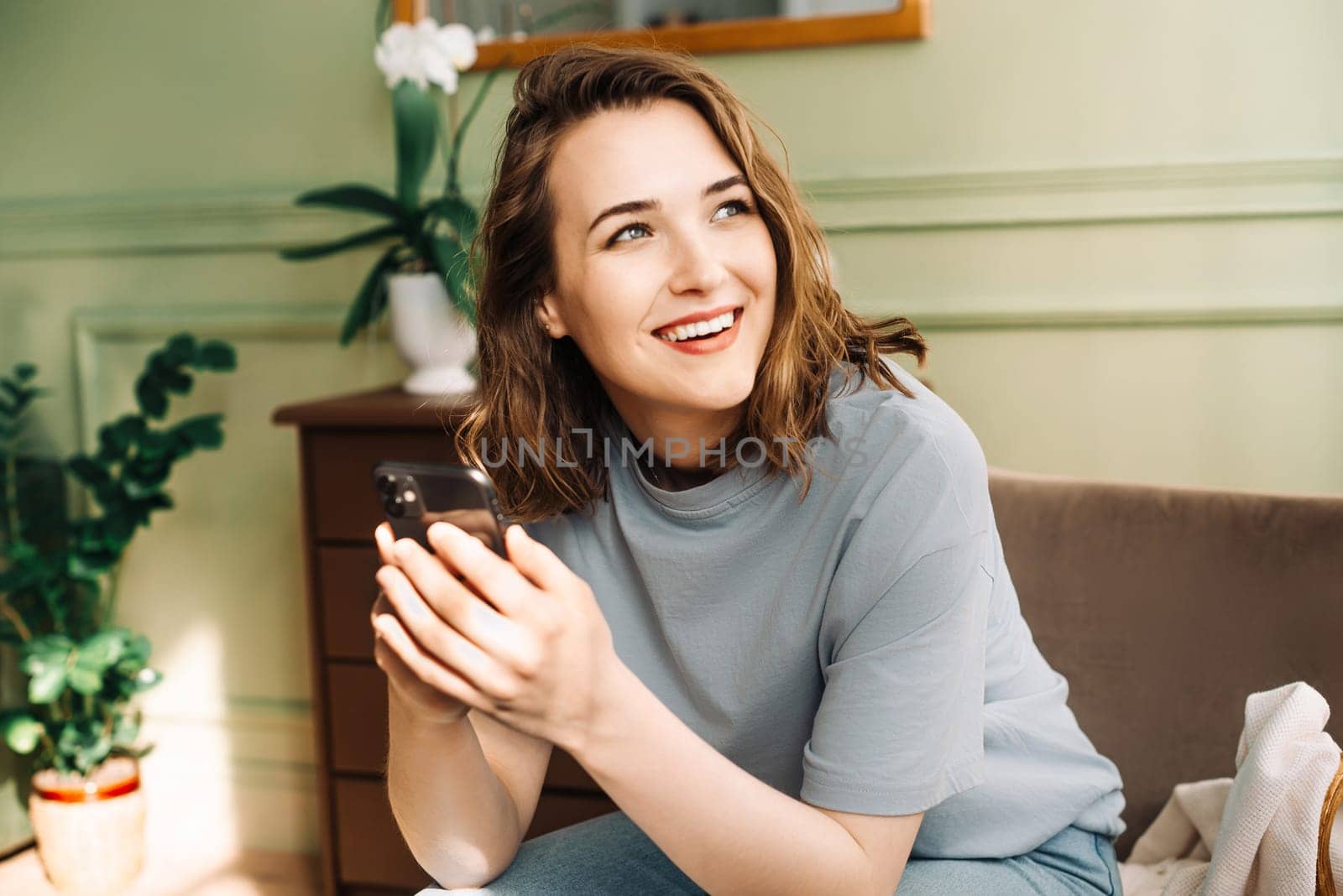 Connected Joy. Happy Woman Engaged in Smartphone Social Chat. Cheerful Online Conversations. Young Woman Typing on Smartphone. Digital Socializing. Smiling Woman Engaged in Smartphone Chat.