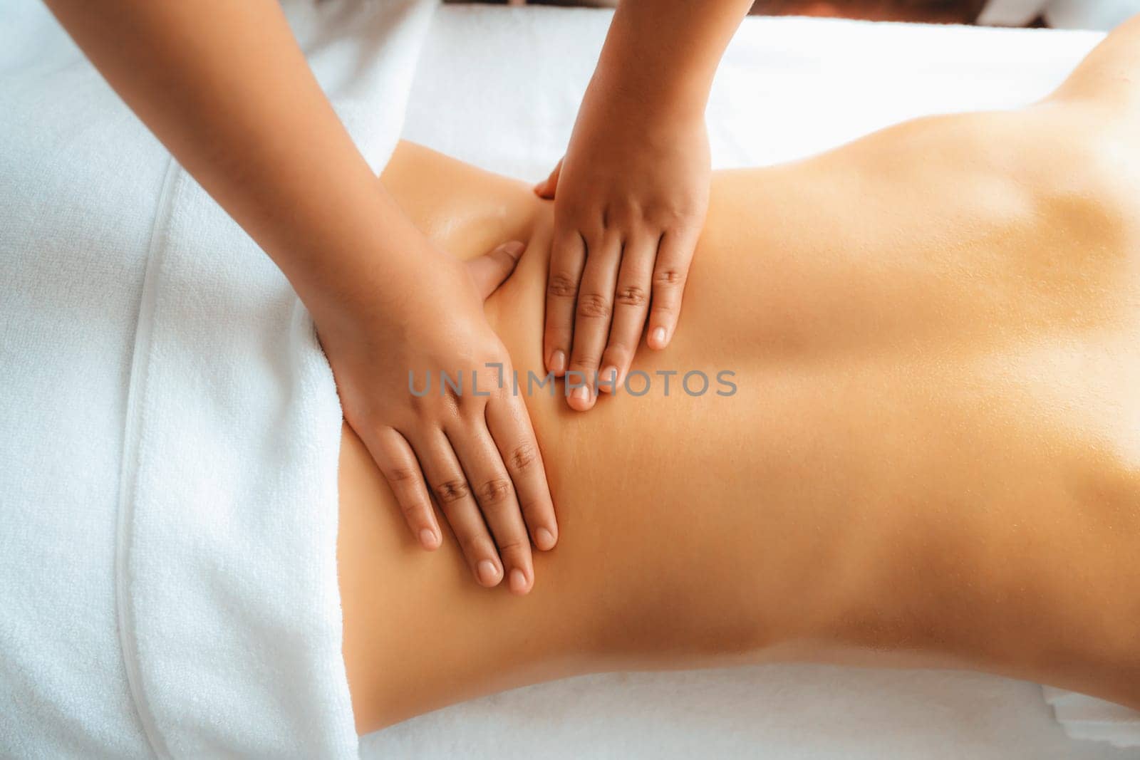 Closeup woman customer enjoying relaxing anti-stress spa massage and pampering with beauty skin recreation leisure in day light ambient salon spa at luxury resort or hotel. Quiescent
