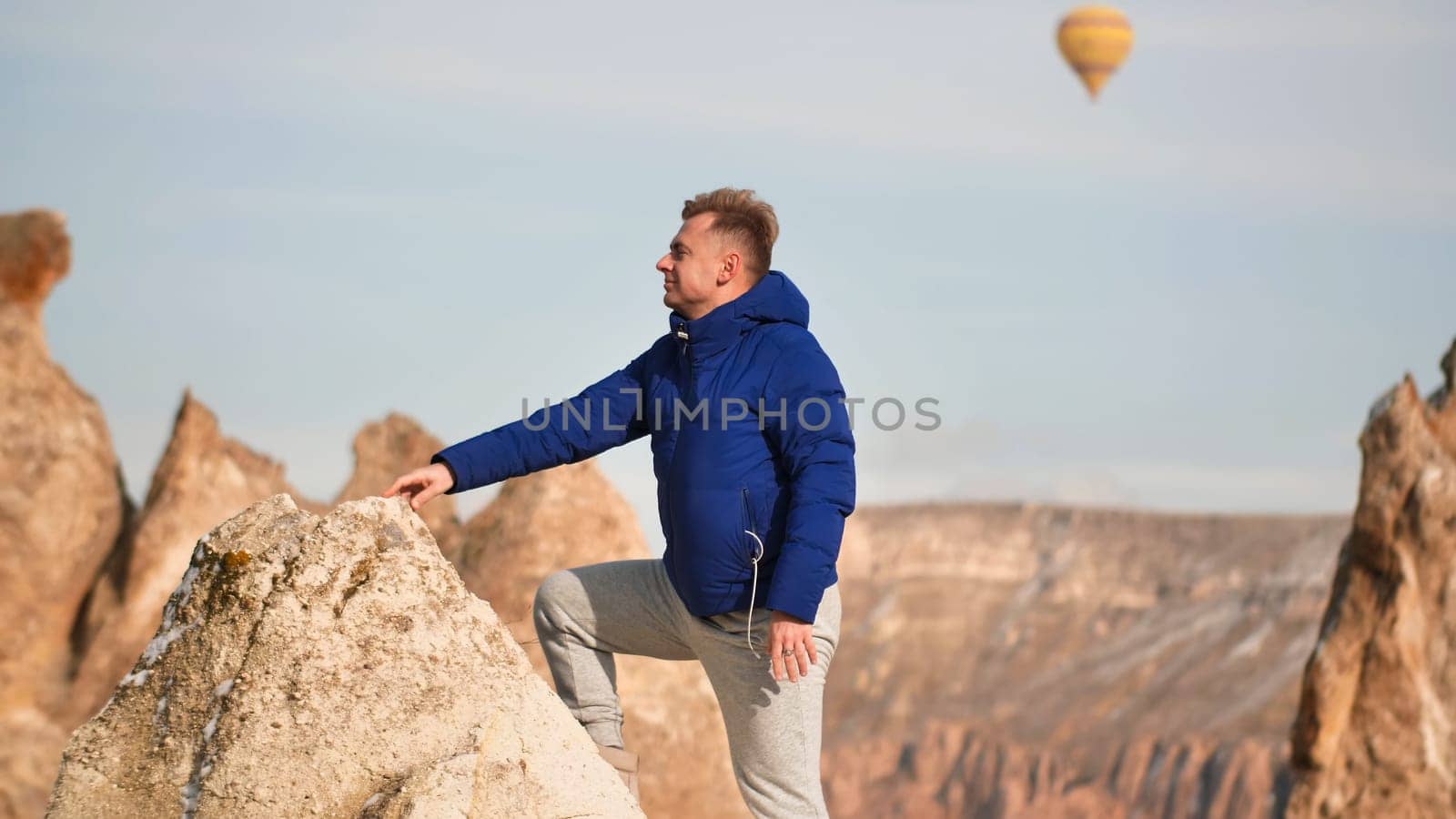 A young man ascended the rocks in Cappadocia