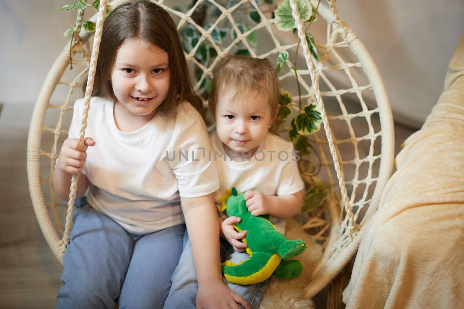 Happy time concept. Girls Sisters in chair and having fun. Female Preschooler and teenager playing and relaxing in room