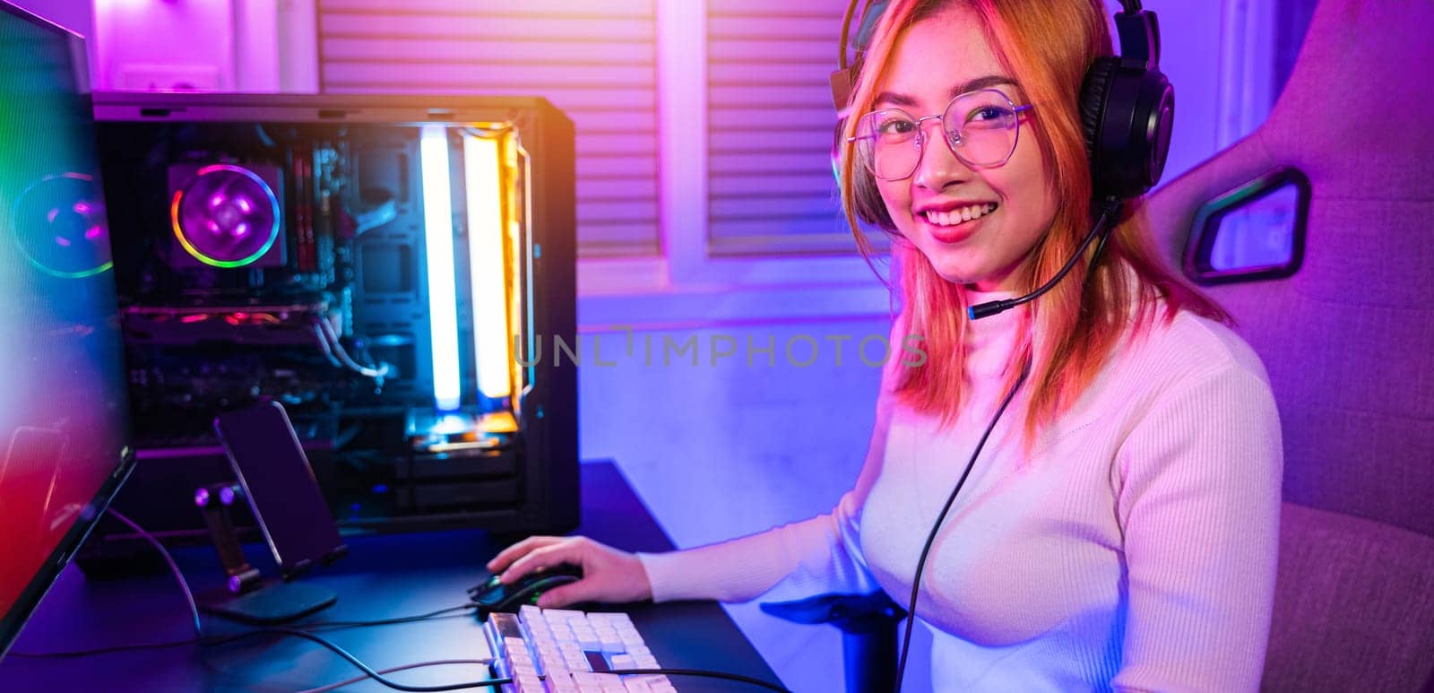 Smiling young woman wearing gaming headphones intend to do playing live stream games online by Sorapop