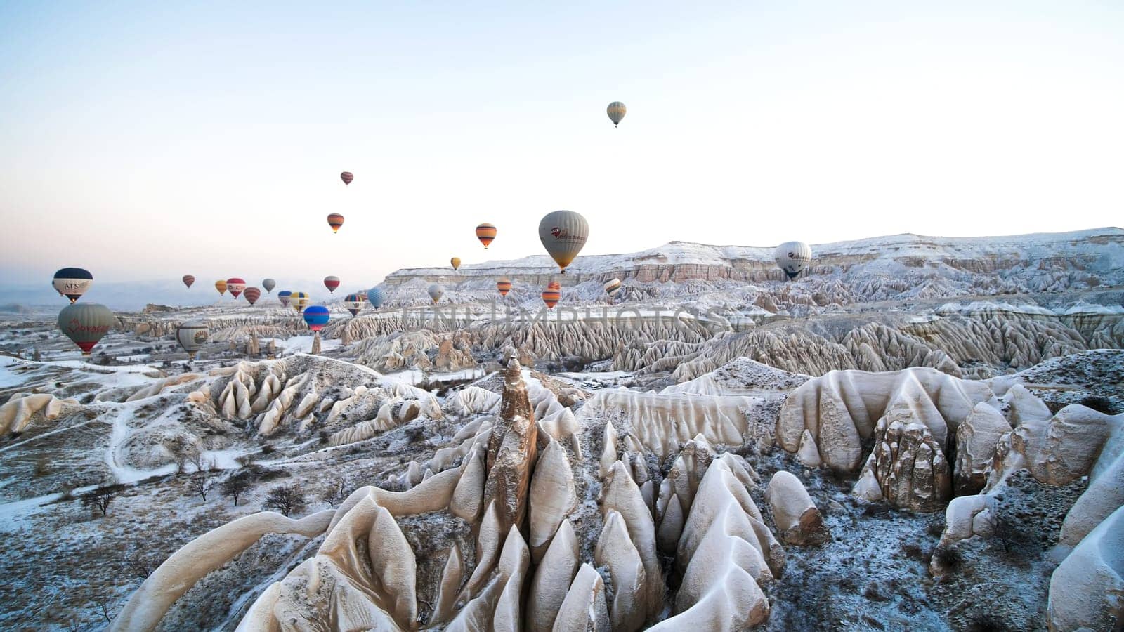 Cappadocia, Turkey - January 6, 2020: Color balloons in the sunrise sky. Cappadocia, Turkey. by DovidPro