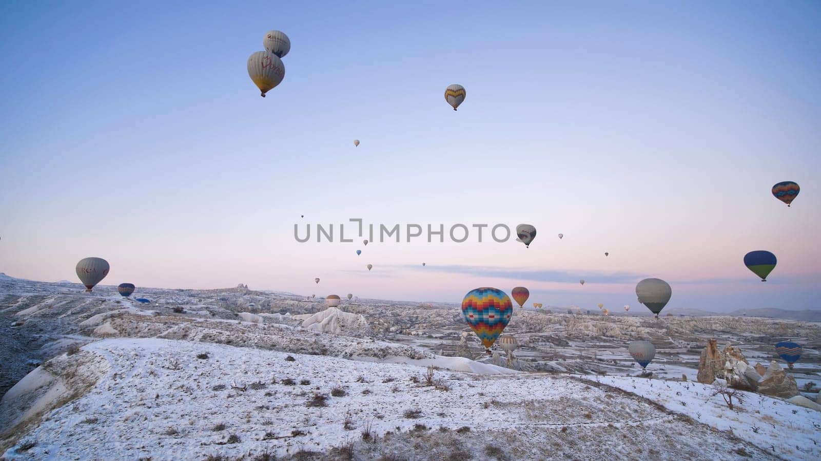 Cappadocia, Turkey - January 6, 2020: Color balloons in the sunrise sky. Cappadocia, Turkey. by DovidPro