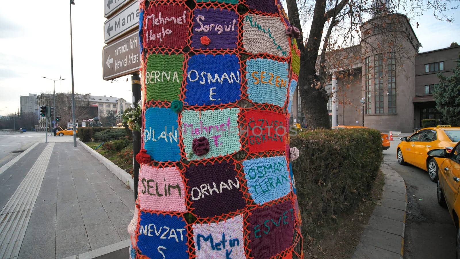 Ankara, Turkey - January 9, 2021: A tree trunk entwined with fabrics near the railway station of Ankara. by DovidPro