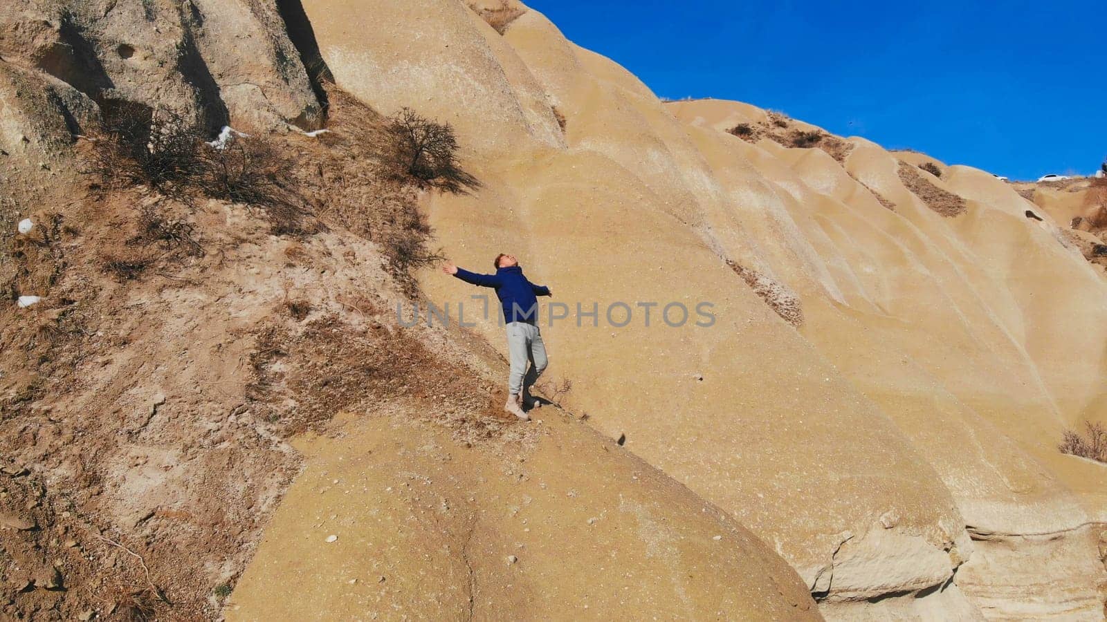 Tourist guy admires World Heritage, Cappadocia, Gereme, Turkey. Beautiful mountains of volcanic origin