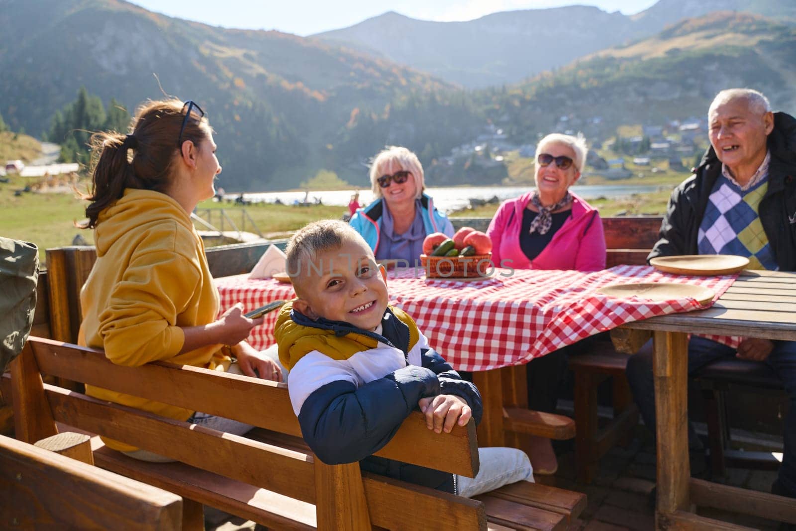 A family on a mountain vacation indulges in the pleasures of a healthy life, savoring traditional pie while surrounded by the breathtaking beauty of nature, fostering family bonds and embracing the vitality of their mountain retreat by dotshock