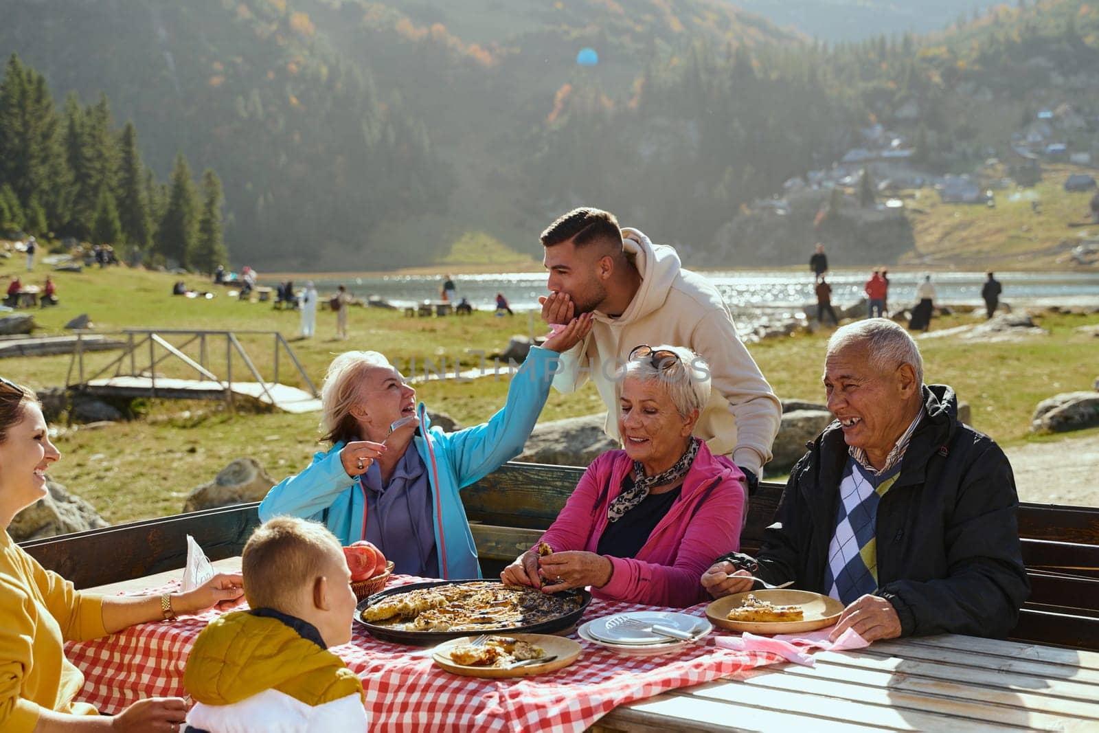 A family on a mountain vacation indulges in the pleasures of a healthy life, savoring traditional pie while surrounded by the breathtaking beauty of nature, fostering family bonds and embracing the vitality of their mountain retreat.
