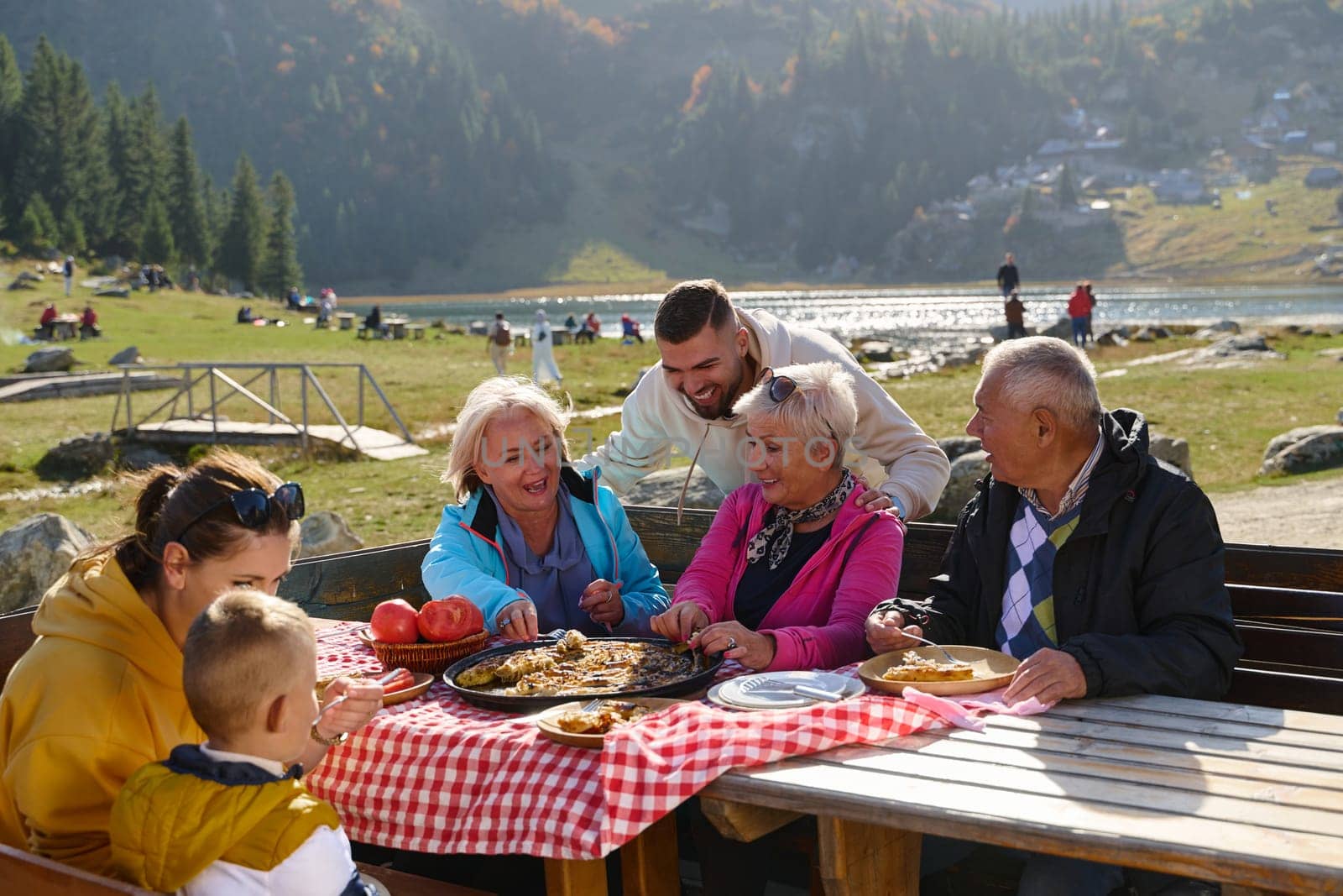 A family on a mountain vacation indulges in the pleasures of a healthy life, savoring traditional pie while surrounded by the breathtaking beauty of nature, fostering family bonds and embracing the vitality of their mountain retreat by dotshock