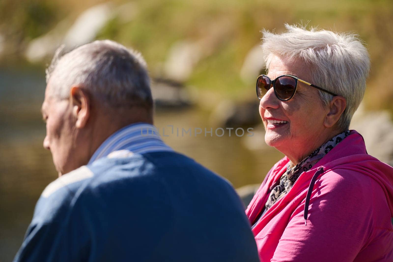 Elderly couple finding solace and joy as they rest on a park bench, engaged in heartfelt conversation, following a rejuvenating strol a testament to the enduring companionship and serene connection that accompanies the golden years by dotshock