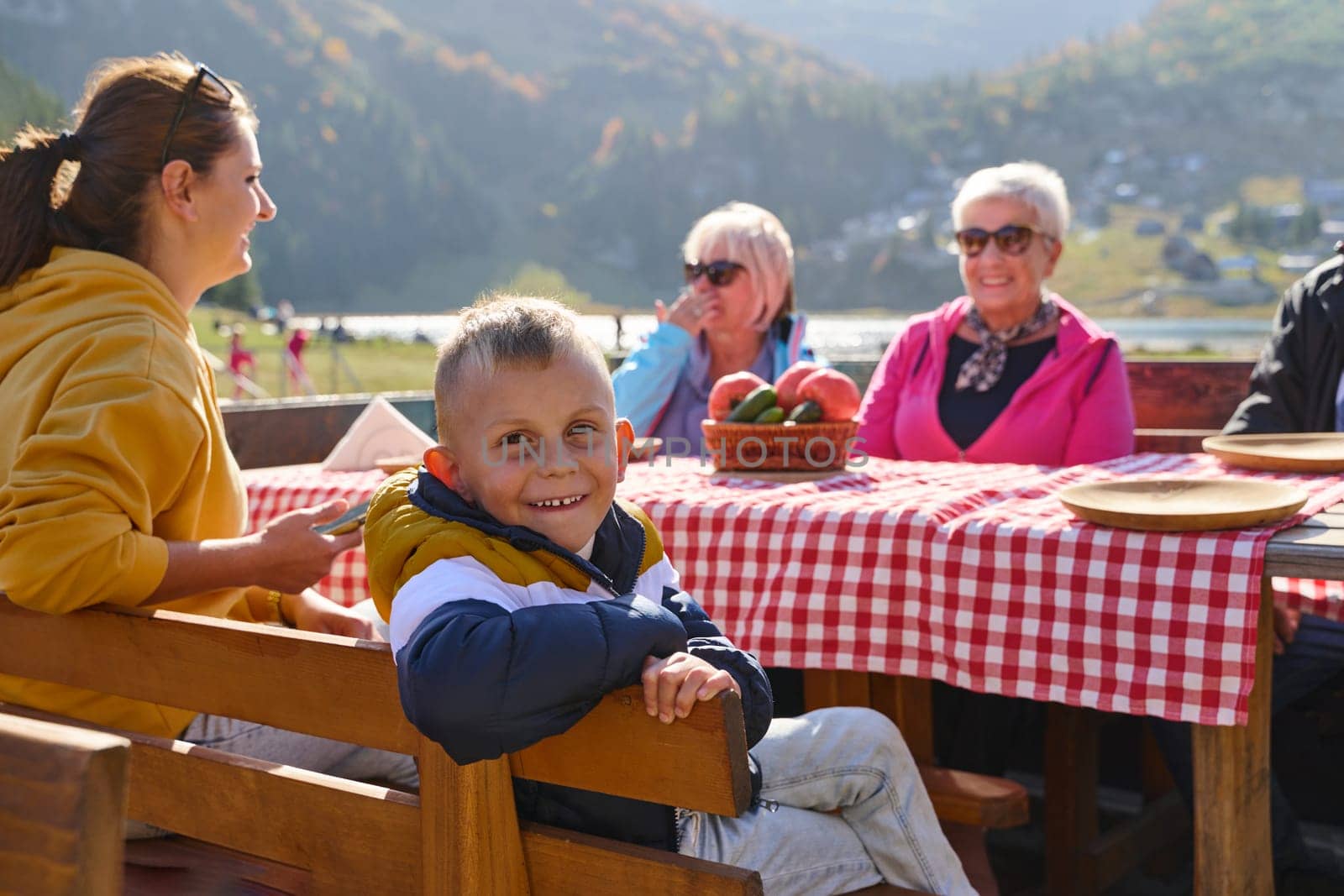 A family on a mountain vacation indulges in the pleasures of a healthy life, savoring traditional pie while surrounded by the breathtaking beauty of nature, fostering family bonds and embracing the vitality of their mountain retreat by dotshock