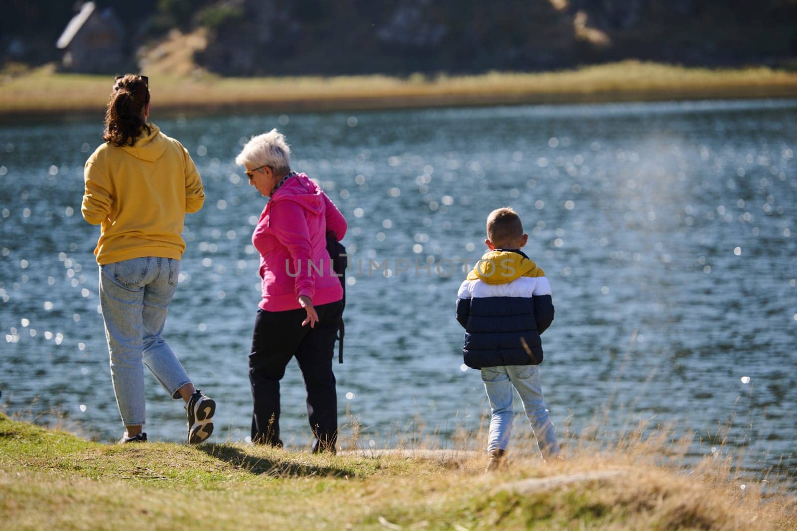 A family shares delightful moments with their friends amid the stunning landscapes of mountains, lakes, and winding paths, promoting a healthy lifestyle and the joy of familial bonds in the embrace of nature's beauty.