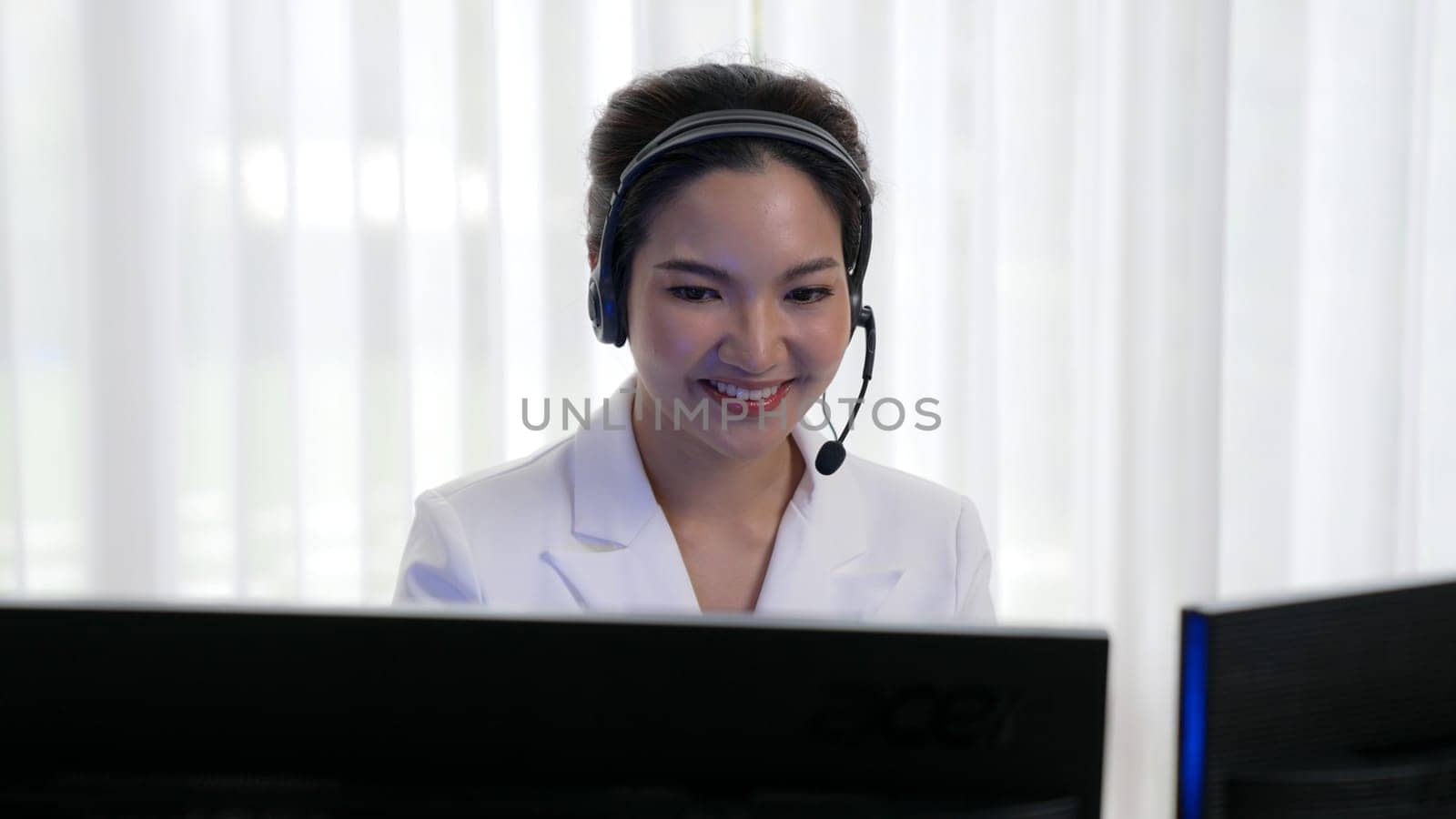 Businesswoman wearing vivancy headset working in office to support remote customer or colleague. Call center, telemarketing, customer support agent provide service on telephone video conference call