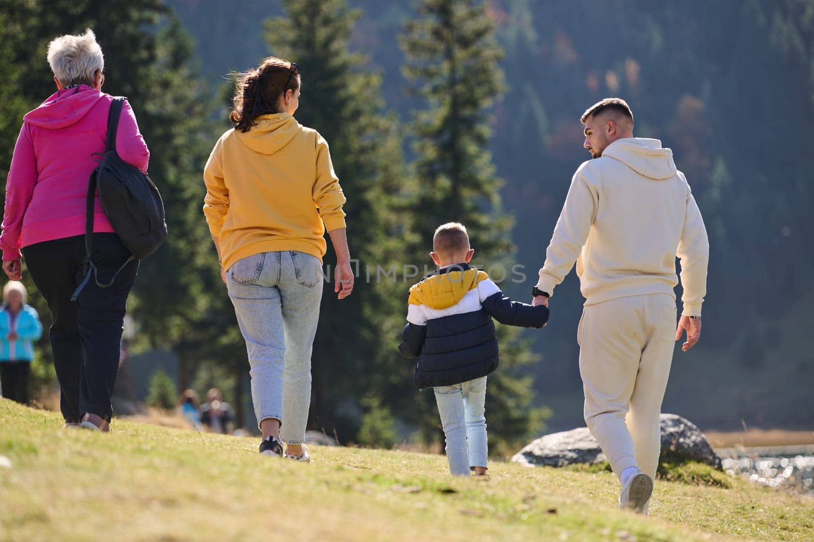 A family shares delightful moments with their friends amid the stunning landscapes of mountains, lakes, and winding paths, promoting a healthy lifestyle and the joy of familial bonds in the embrace of nature's beauty.