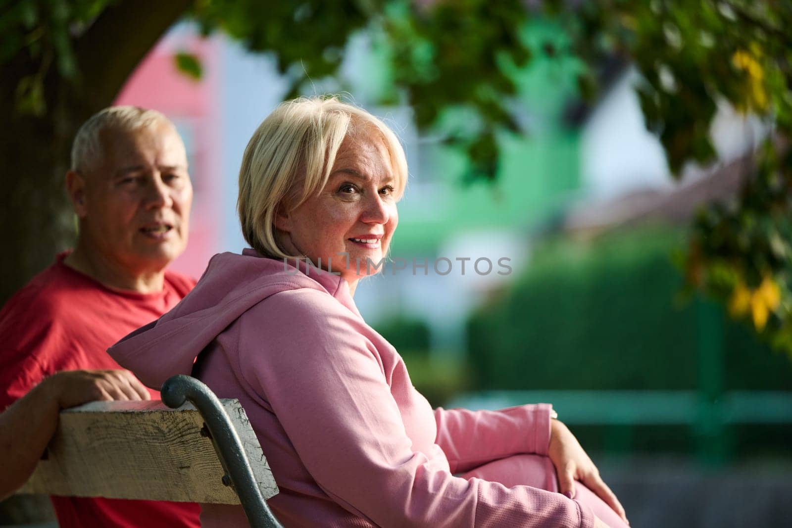 Elderly couple finding solace and joy as they rest on a park bench, engaged in heartfelt conversation, following a rejuvenating strol a testament to the enduring companionship and serene connection that accompanies the golden years by dotshock