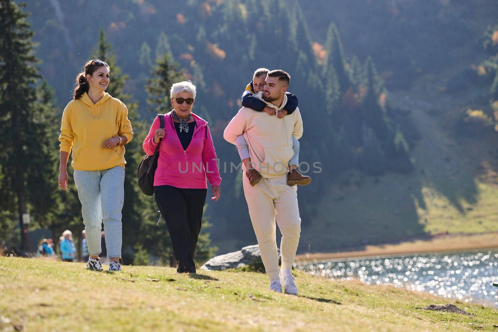 A family shares delightful moments with their friends amid the stunning landscapes of mountains, lakes, and winding paths, promoting a healthy lifestyle and the joy of familial bonds in the embrace of nature's beauty.