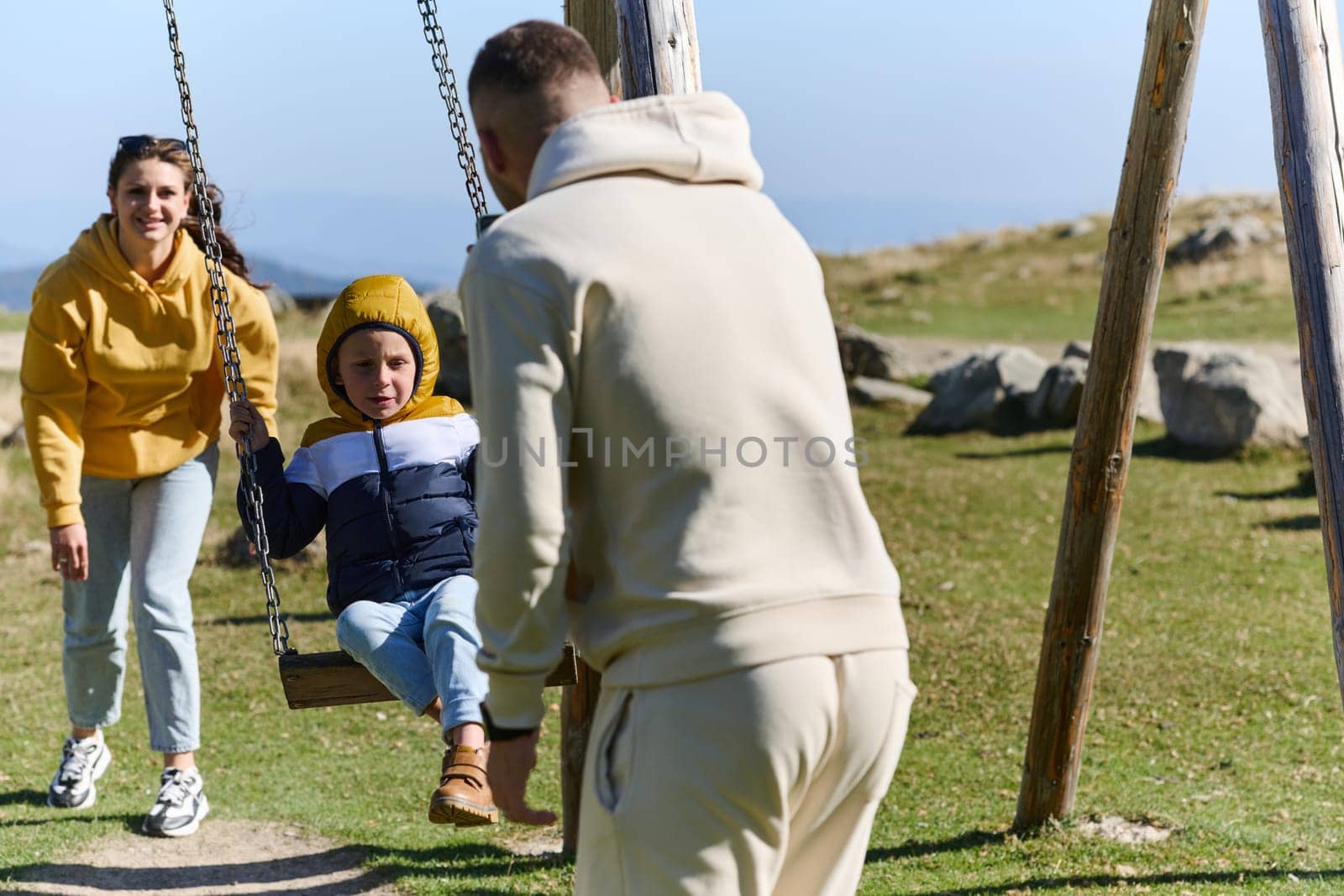 A modern family, along with their son, revels in the joy of a muddy day in nature, running and playing together, encapsulating the beauty of a healthy and active lifestyle.