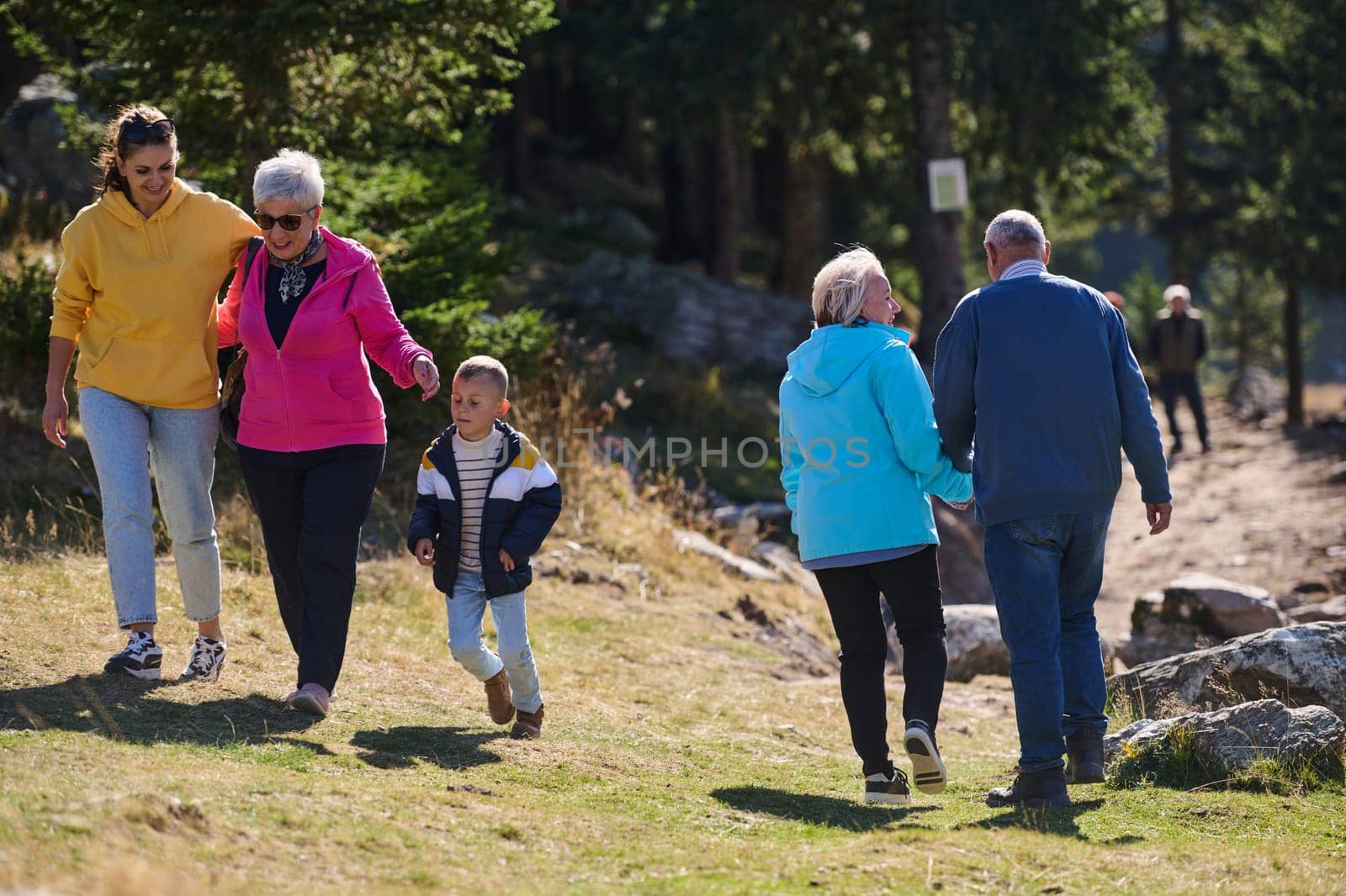 A family shares delightful moments with their friends amid the stunning landscapes of mountains, lakes, and winding paths, promoting a healthy lifestyle and the joy of familial bonds in the embrace of nature's beauty.