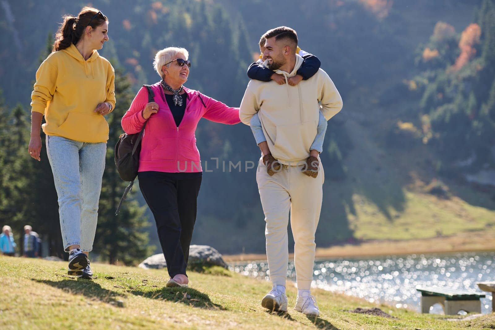 A family shares delightful moments with their friends amid the stunning landscapes of mountains, lakes, and winding paths, promoting a healthy lifestyle and the joy of familial bonds in the embrace of nature's beauty.