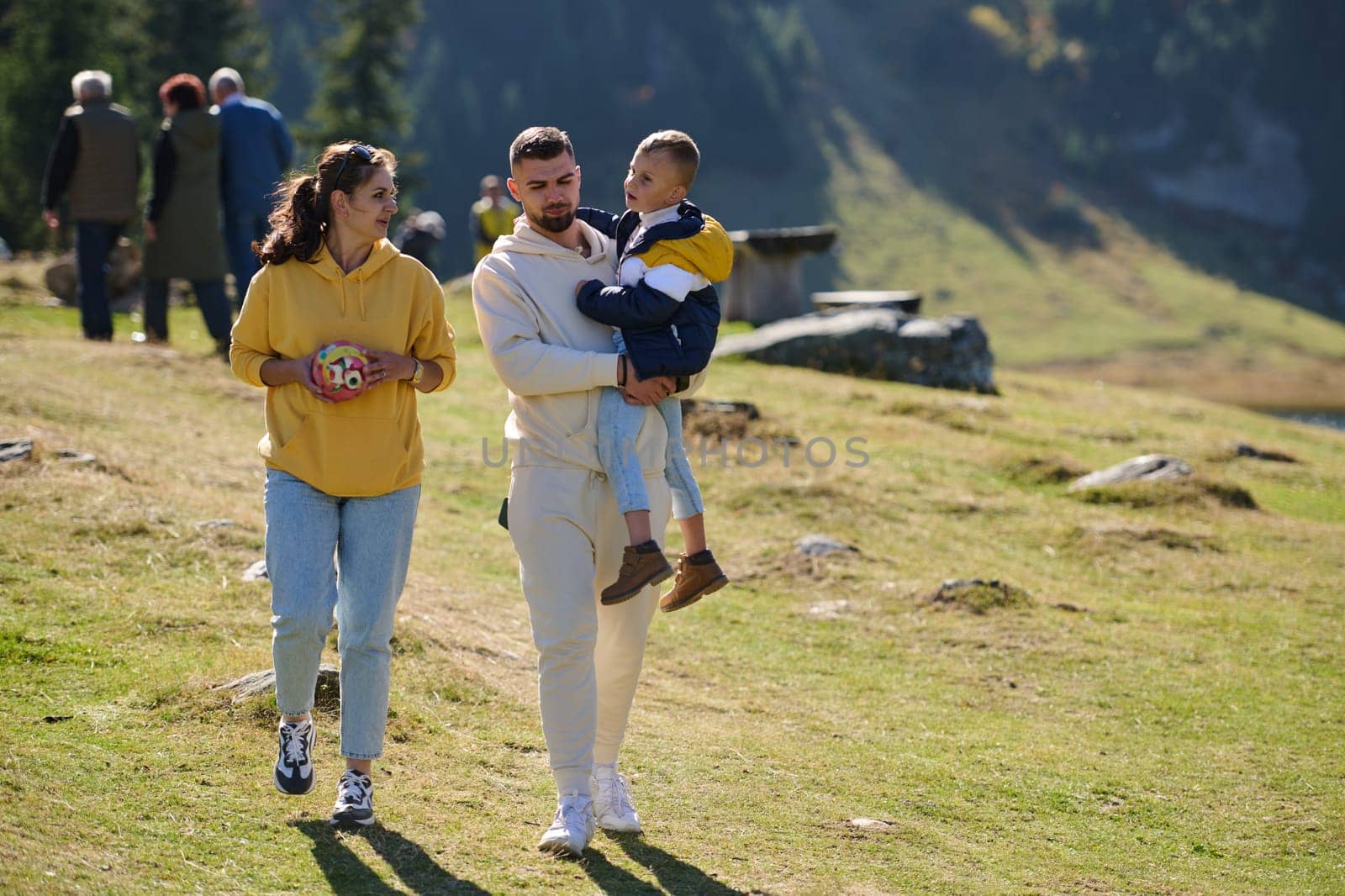 A modern family, along with their son, revels in the joy of a muddy day in nature, running and playing together, encapsulating the beauty of a healthy and active lifestyle.