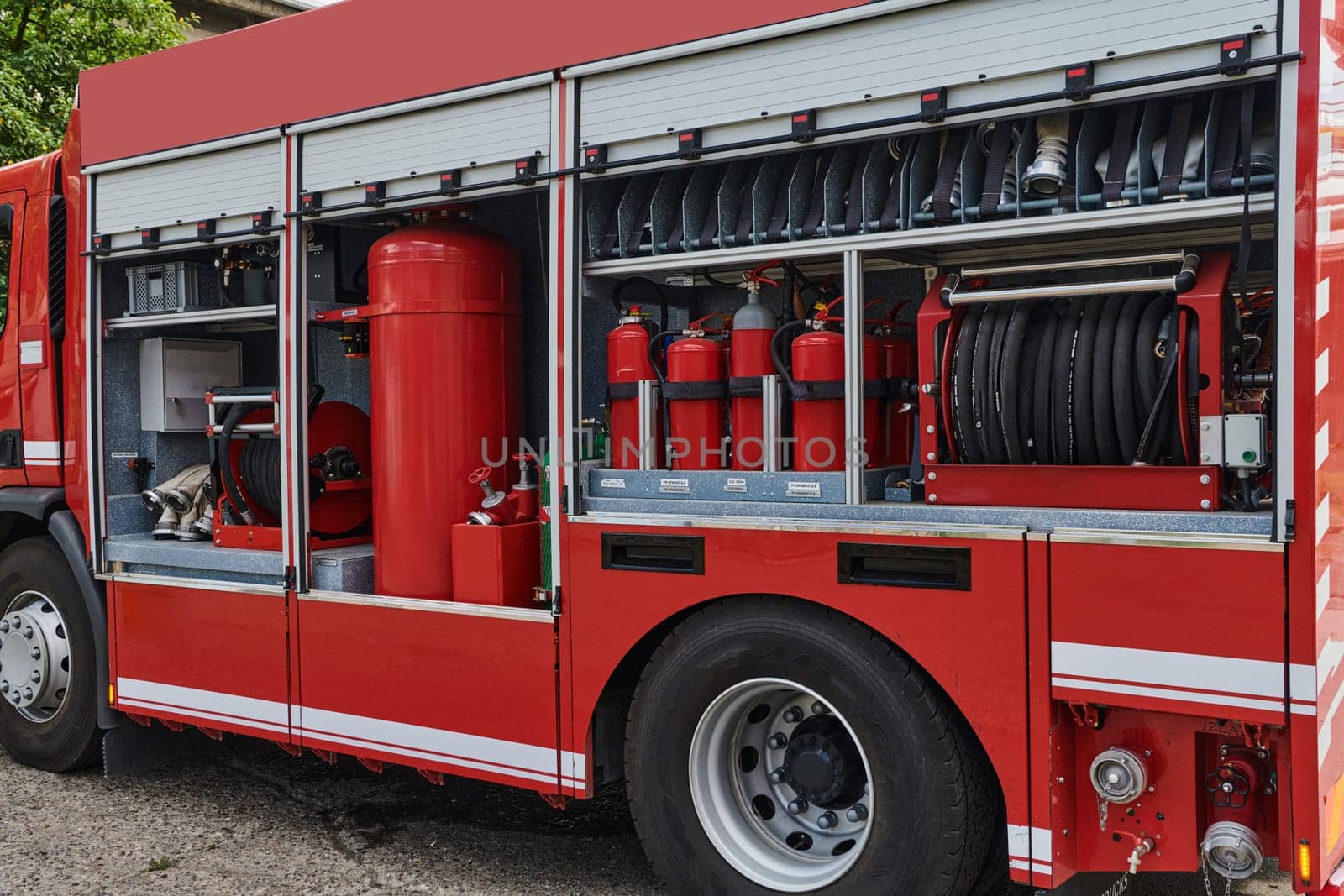 A state-of-the-art firetruck, equipped with advanced rescue technology, stands ready with its skilled firefighting team, prepared to intervene and respond rapidly to emergencies, ensuring the safety and protection of the community. High quality photo