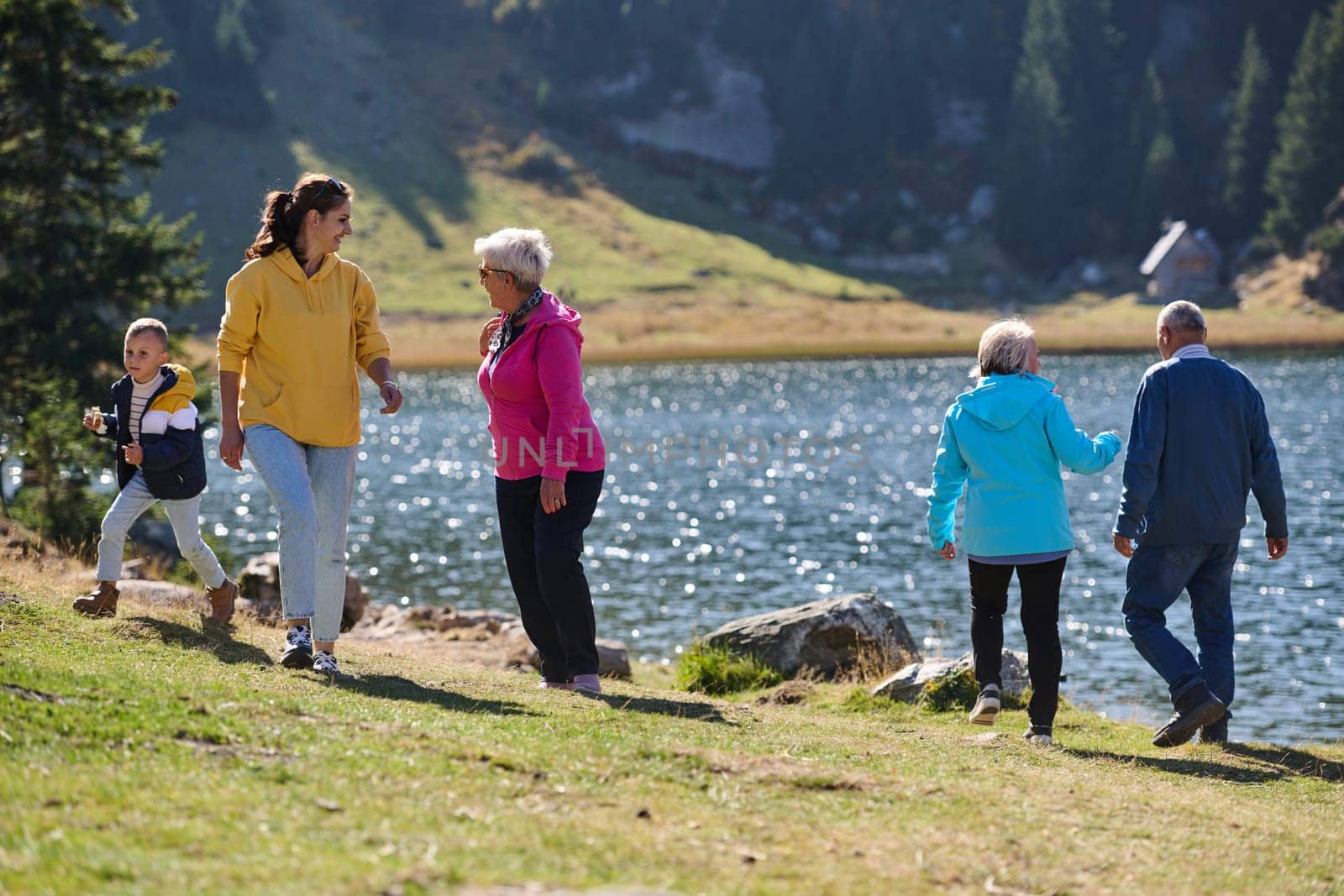 A family shares delightful moments with their friends amid the stunning landscapes of mountains, lakes, and winding paths, promoting a healthy lifestyle and the joy of familial bonds in the embrace of nature's beauty.