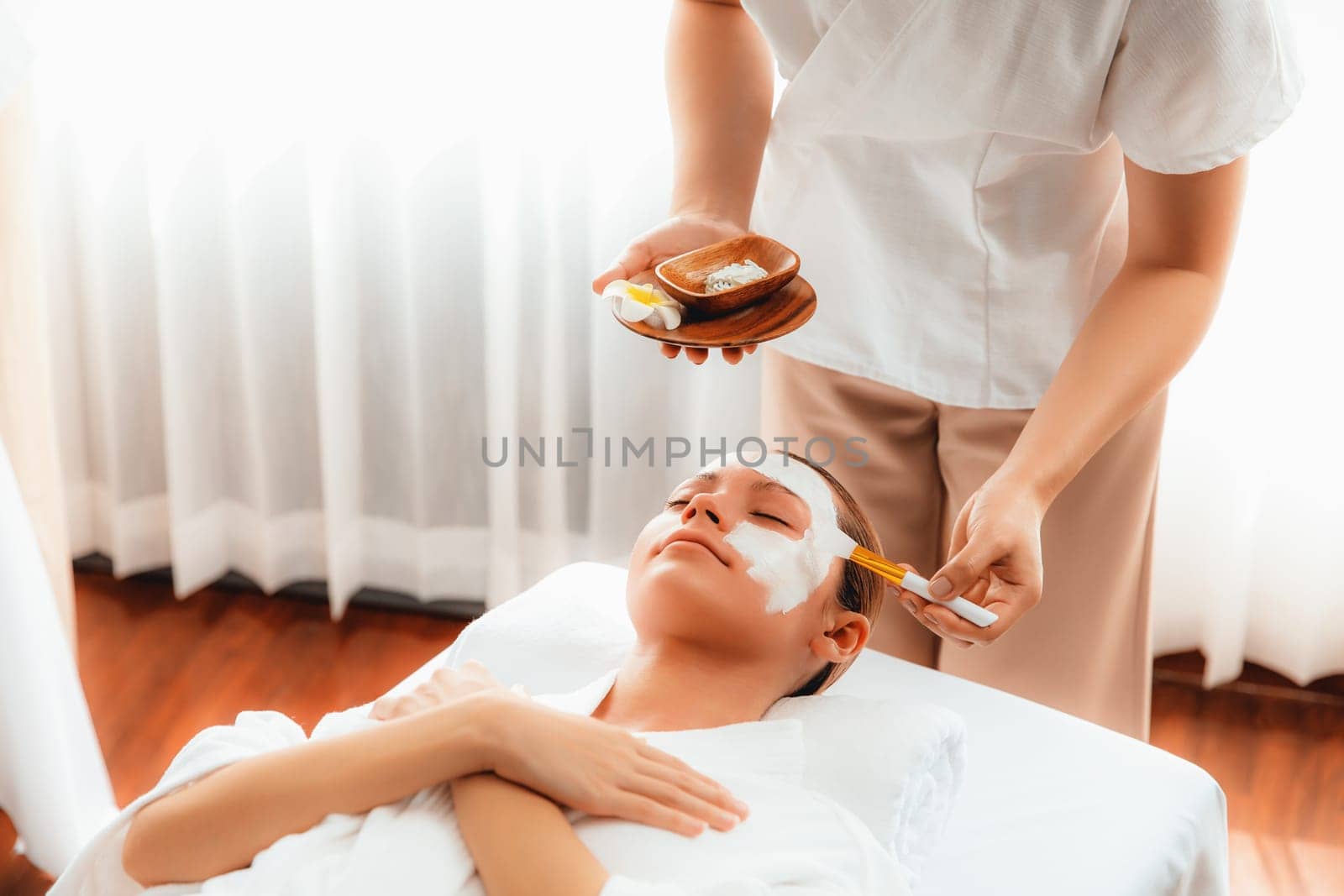 Woman indulges in rejuvenating with luxurious face cream spa massage. Quiescent by biancoblue