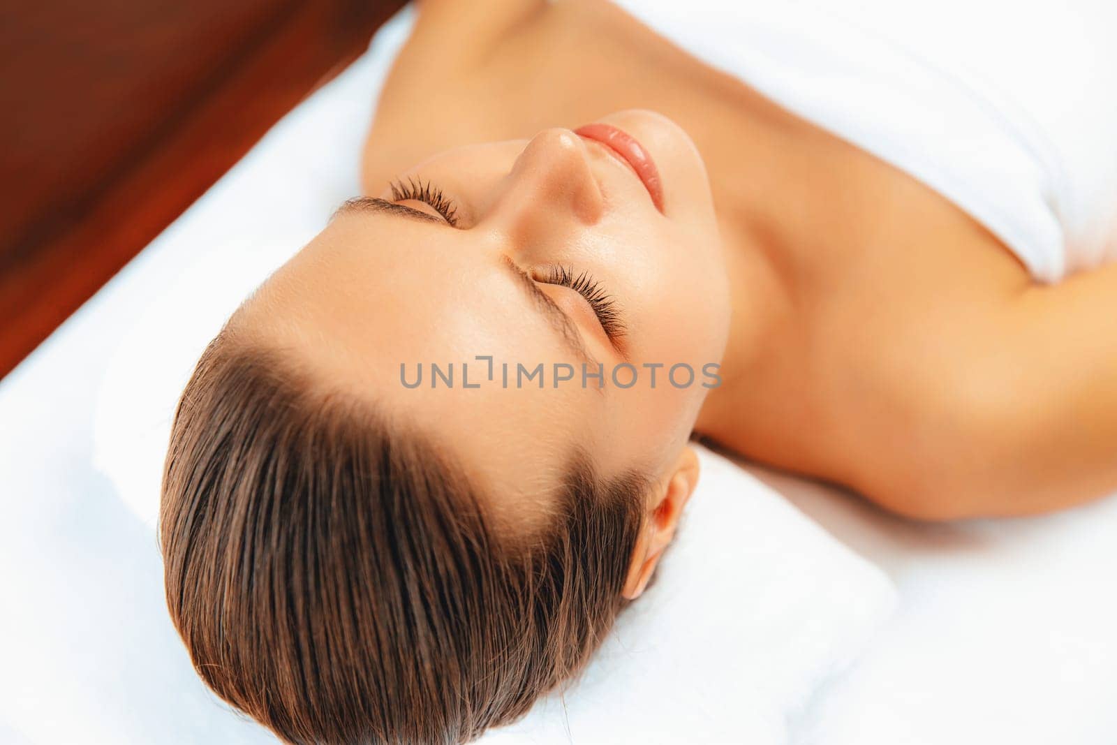 Closeup caucasian woman customer enjoying relaxing anti-stress spa massage and pampering with beauty skin recreation leisure in day light ambient salon spa at luxury resort or hotel. Quiescent