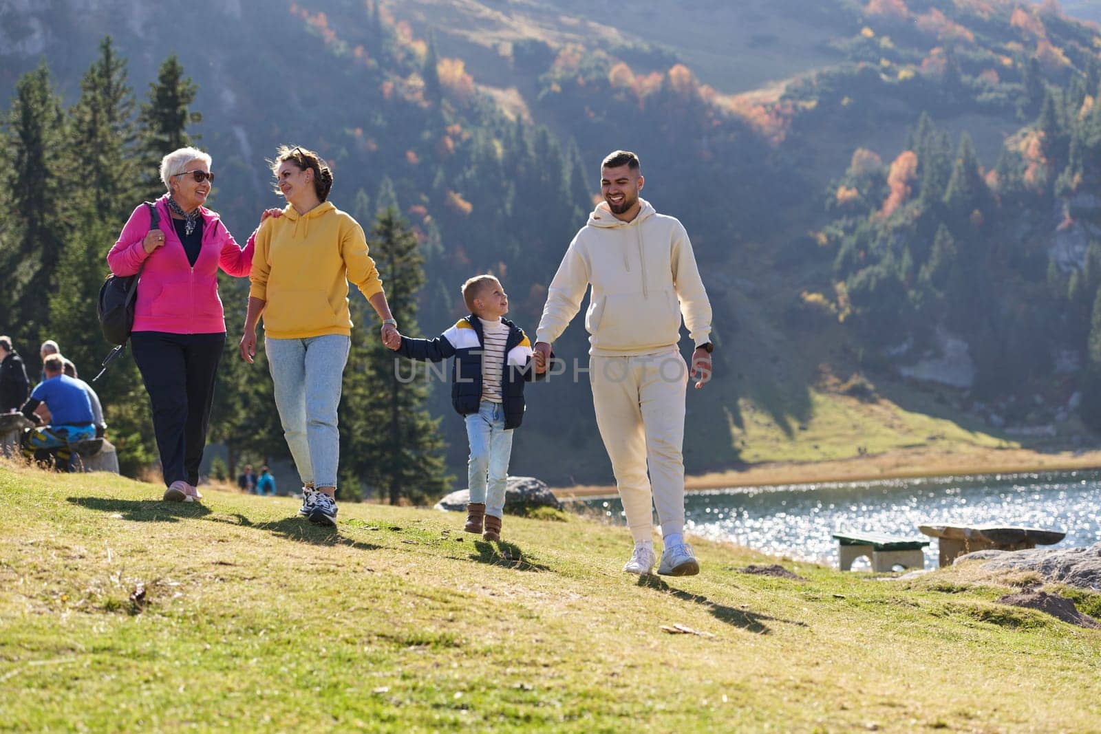 A family shares delightful moments with their friends amid the stunning landscapes of mountains, lakes, and winding paths, promoting a healthy lifestyle and the joy of familial bonds in the embrace of nature's beauty.