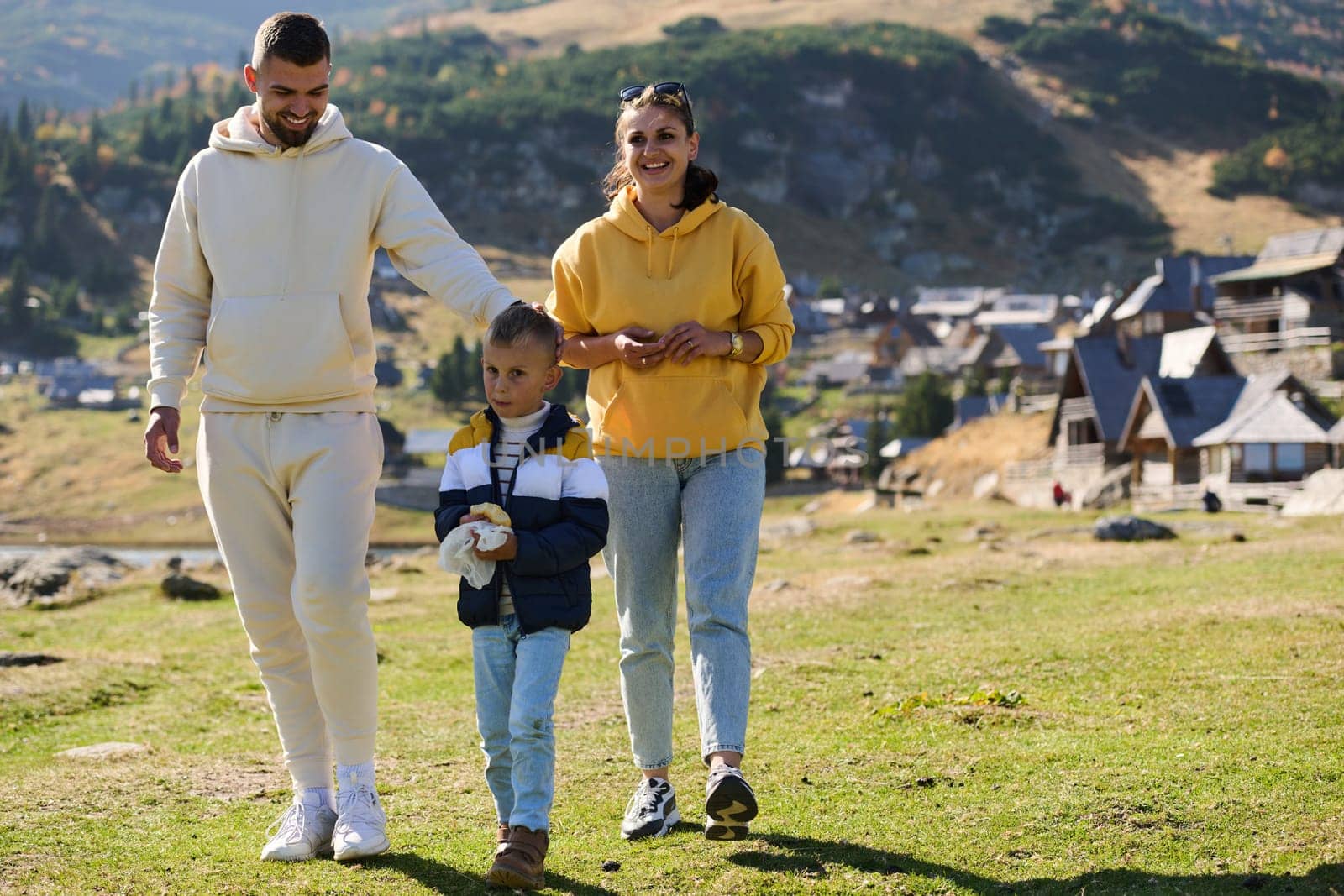 A modern family, along with their son, revels in the joy of a muddy day in nature, running and playing together, encapsulating the beauty of a healthy and active lifestyle.