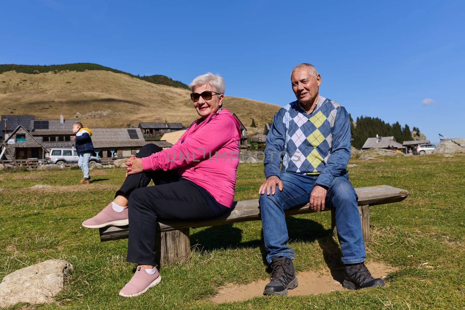 Elderly couple finding solace and joy as they rest on a park bench, engaged in heartfelt conversation, following a rejuvenating strol a testament to the enduring companionship and serene connection that accompanies the golden years.