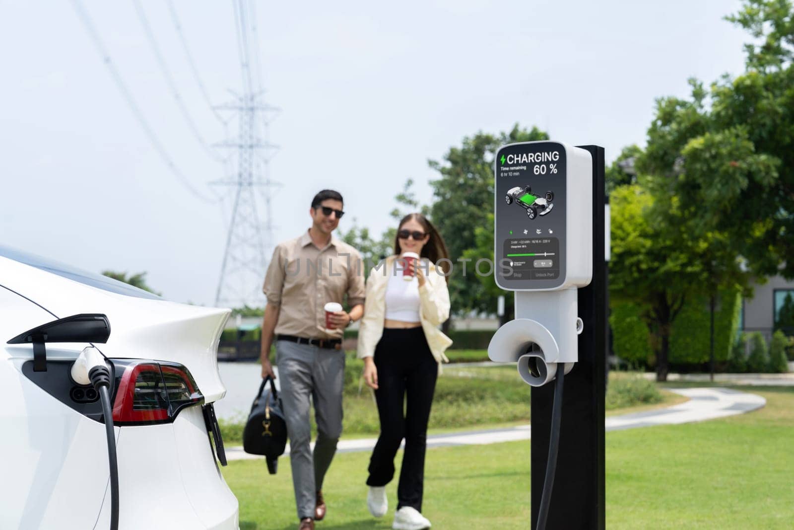 Young couple recharge EV car battery at charging station. Expedient by biancoblue