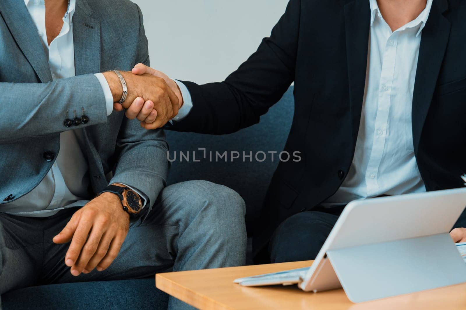 Businessmen handshake business deal in office. uds by biancoblue